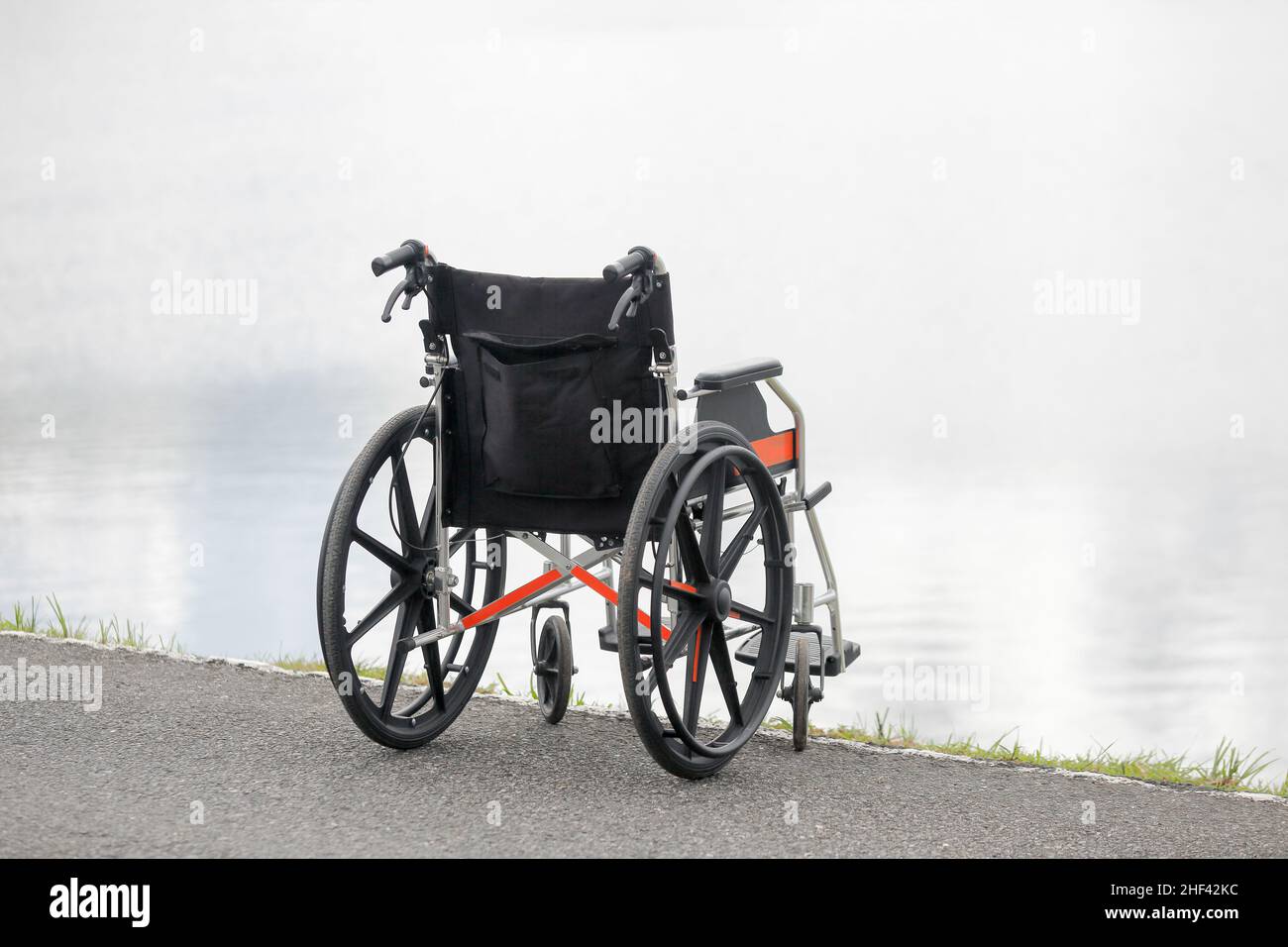 Leerer Rollstuhl am See Stockfoto