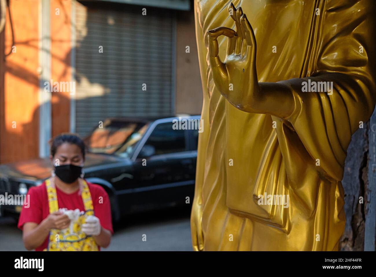 Buddha-Statue mit Hand in Vitarka Mudra, eine Geste, die die Vermittlung von Wissen symbolisiert; vor einem buddhistischen Geschäft, Bamrung Muang Rd, Bangkok, Thailand Stockfoto