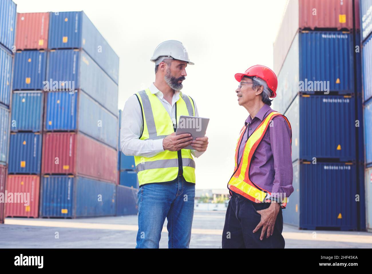Vorarbeiter und Ingenieur Treffen und Kontrolle Verladung Container Box von Cargo Frachtschiff für den Import Export. Frachtcontainer im Seehafen. Stockfoto