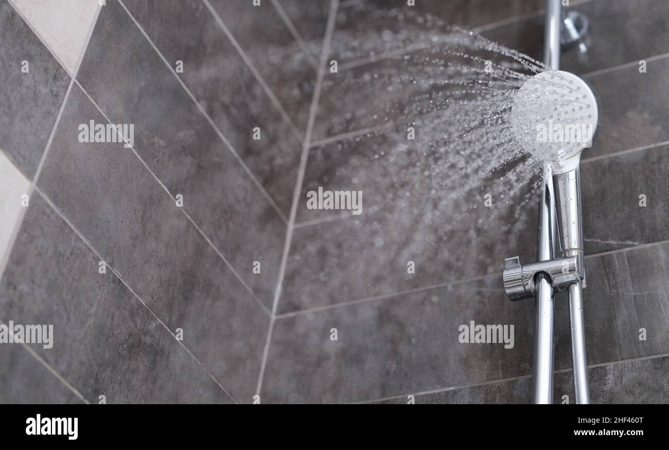 Wasser strömt aus der Dusche in die Dusche, Nahaufnahme. Erfrischende Dusche, Sauberkeit und Hygiene Stockfoto