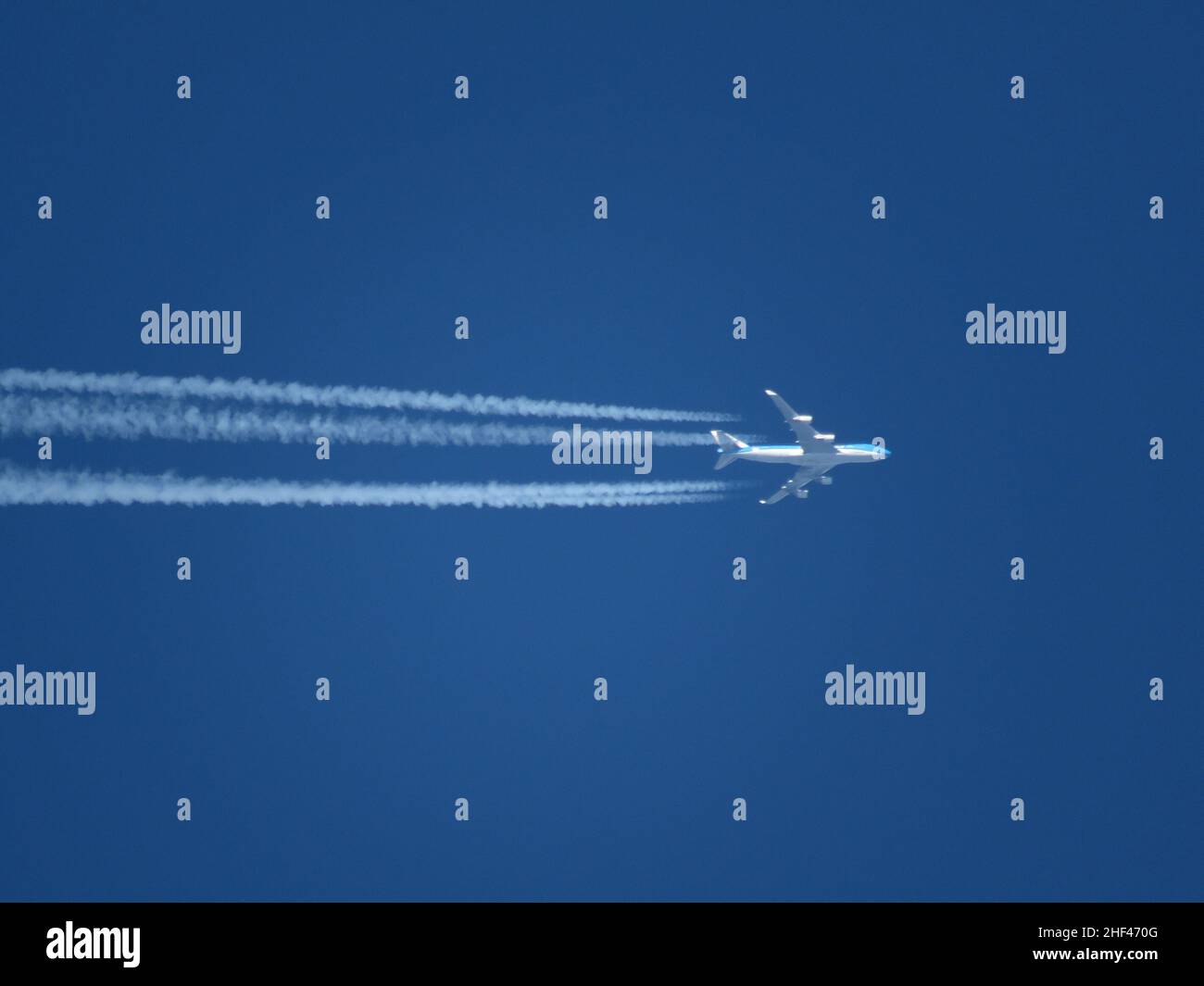 Teleaufnahme eines KLM Boeing 747-Flugzeugs, das in großer Höhe mit Conils in Richtung Amsterdam fliegt. Stockfoto