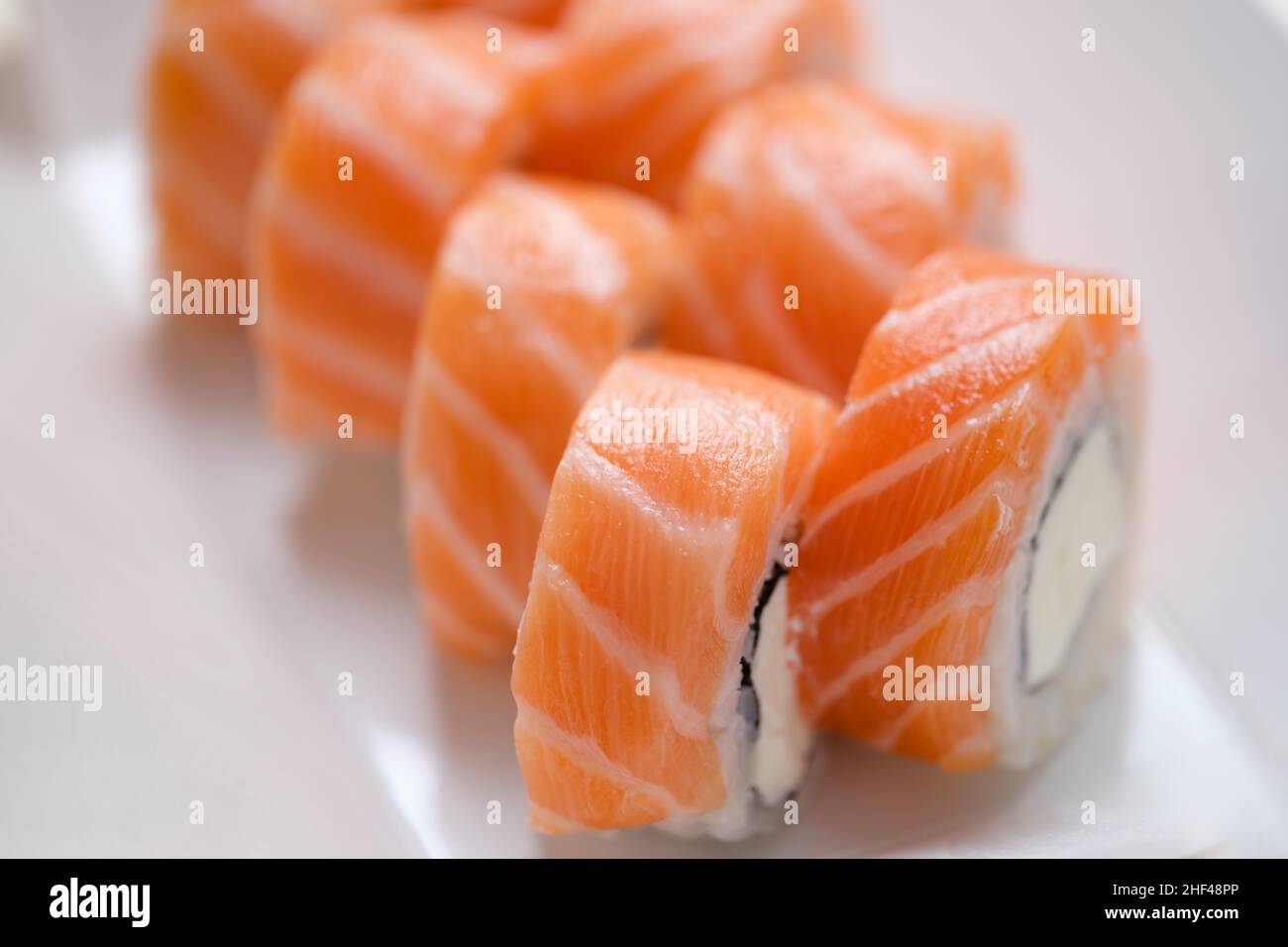 Brötchen Philadelphia mit Lachs und Käse auf weißem Hintergrund, Nahaufnahme. Kochrezept, Sushi bestellen Stockfoto