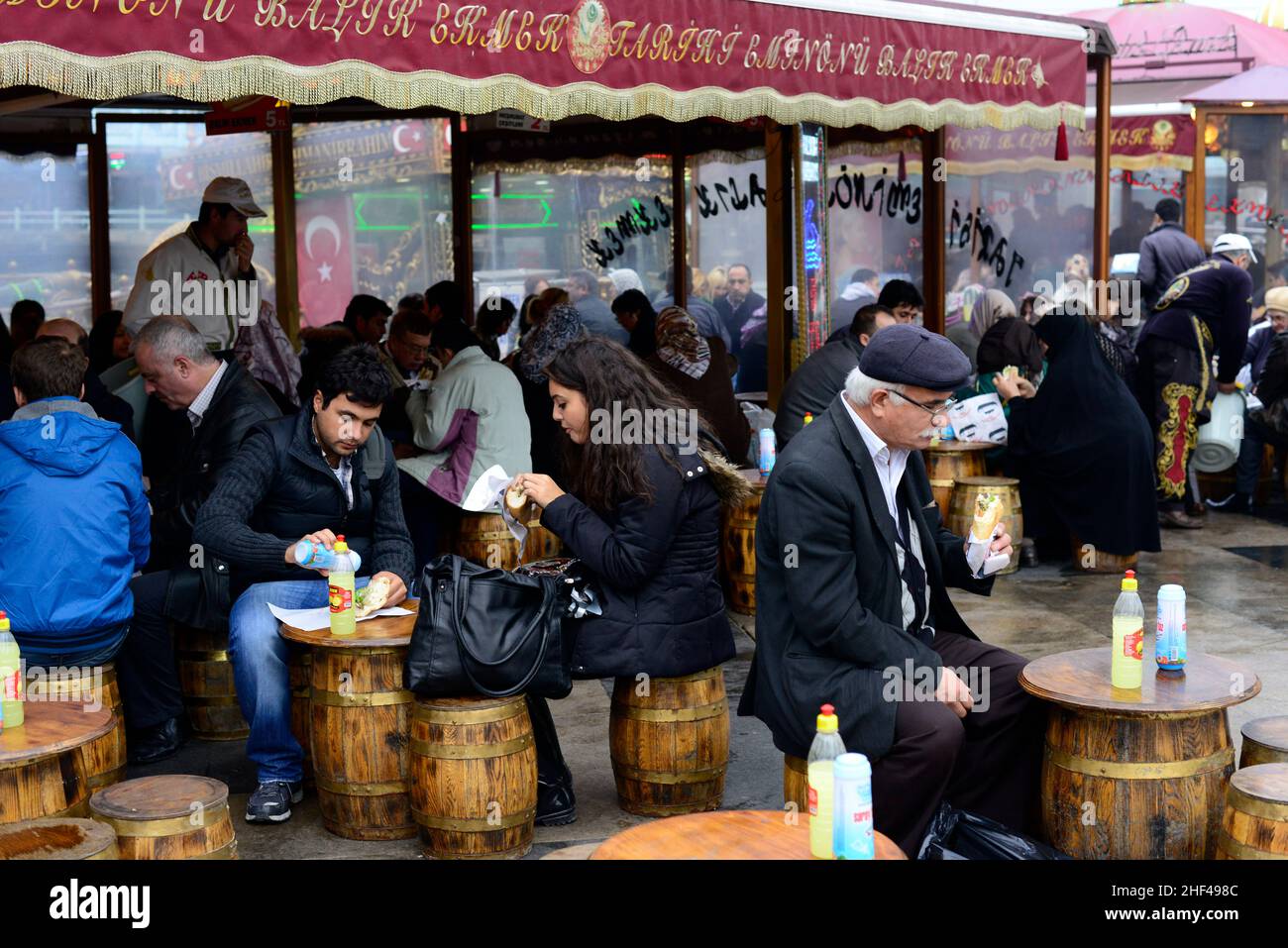 Makrelenfisch, gegrillt für die berühmten Fisch-Sandwiches, serviert von bunten Booten an der Galata-Brücke in Istanbul, Türkei. Stockfoto