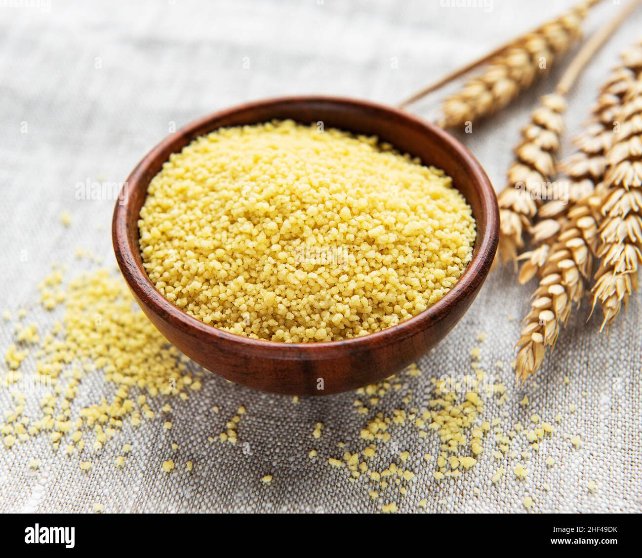 Roher Couscous in einer Holzschale auf dem Tisch Stockfoto