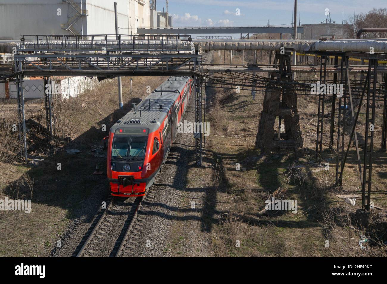 Der rote Zug fährt durch das Industriegebiet. Blick von oben. Stockfoto