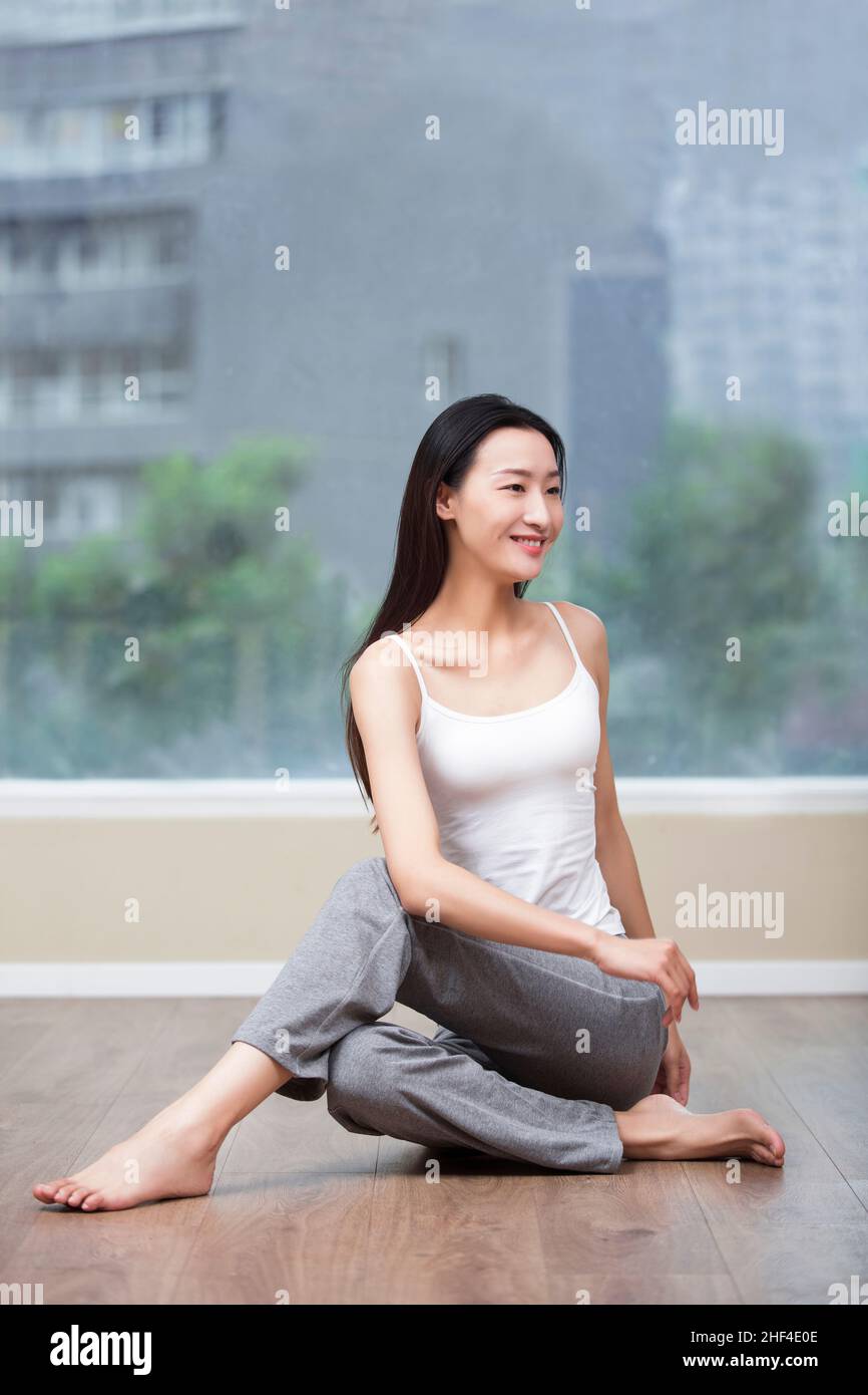 Junge Frau mit Yoga zu Hause Stockfoto