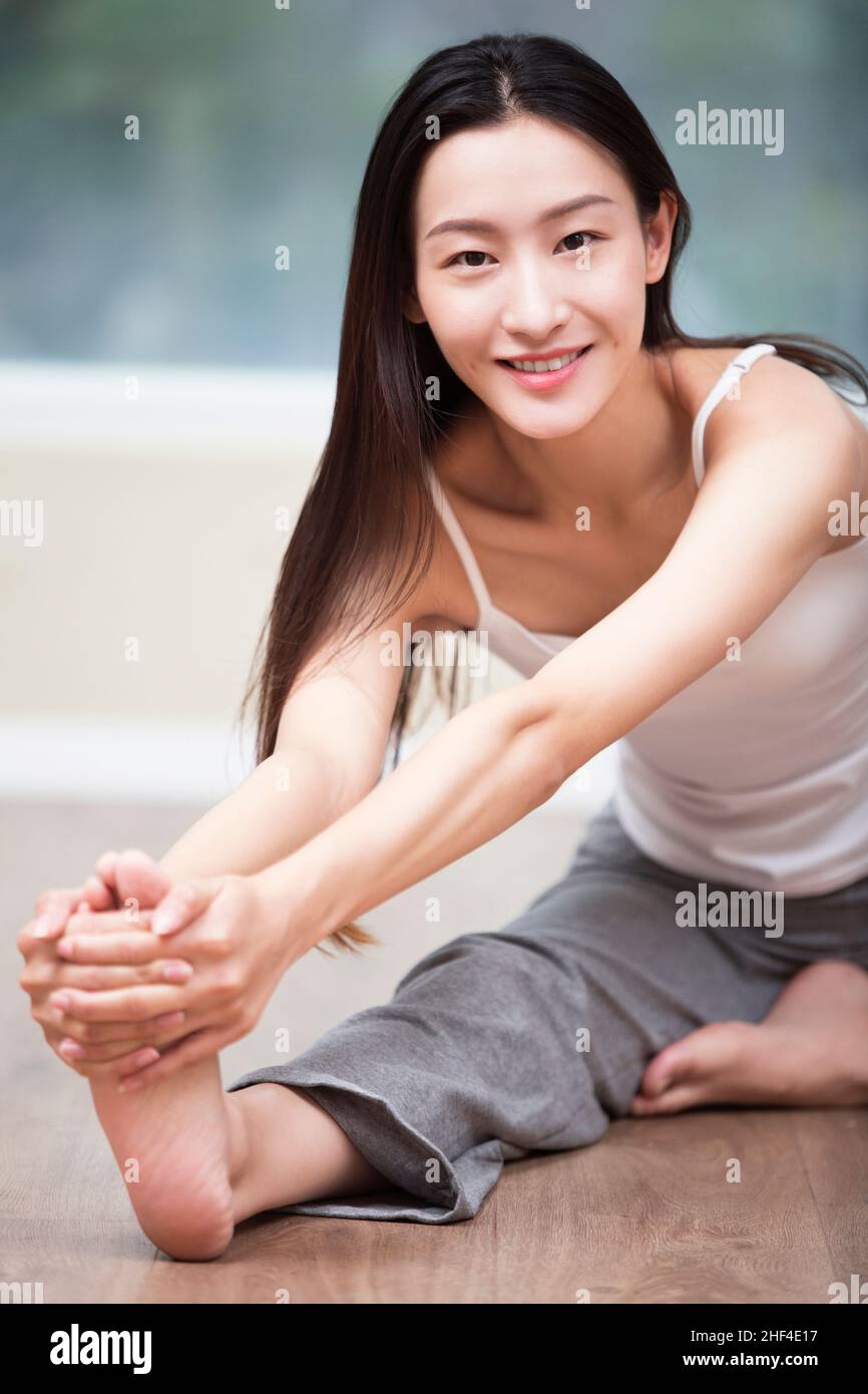 Junge Frau mit Yoga zu Hause Stockfoto