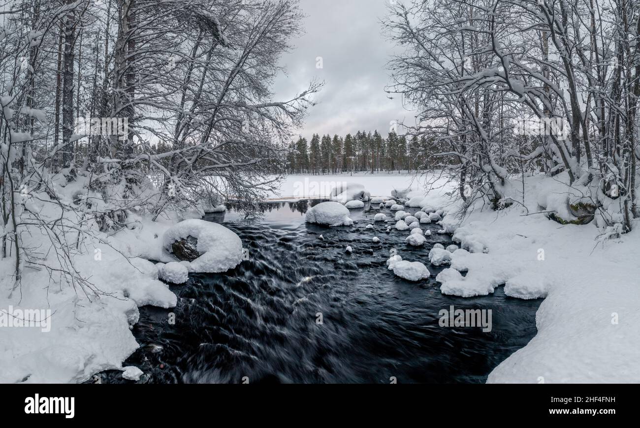 Fließender Fluss in verschneiten Winterlandschaften in Finnland Stockfoto