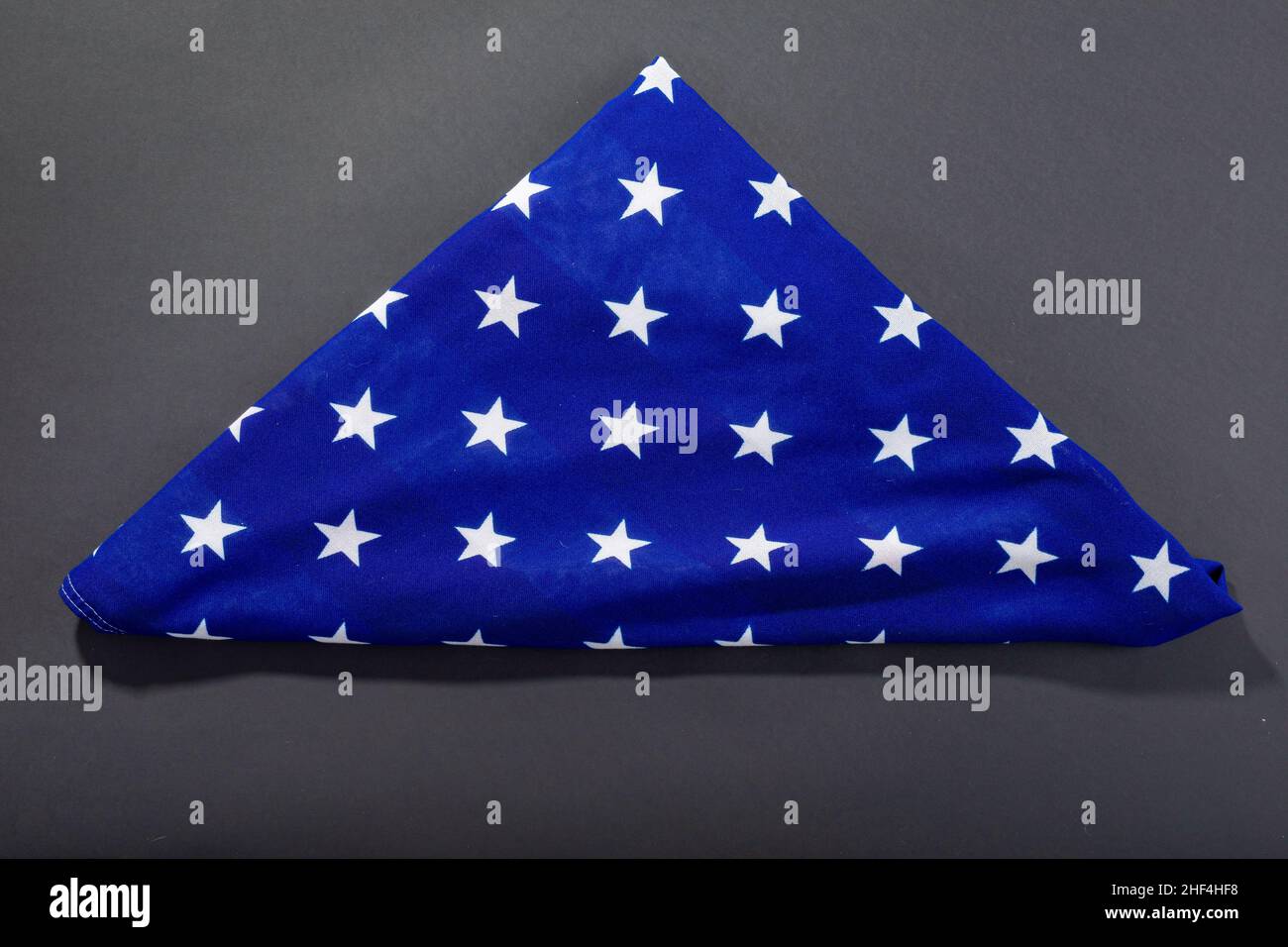 Weiße Sterne auf dreieckiger Form gefaltete amerika-Flagge auf schwarzem Hintergrund mit Kopierraum Stockfoto