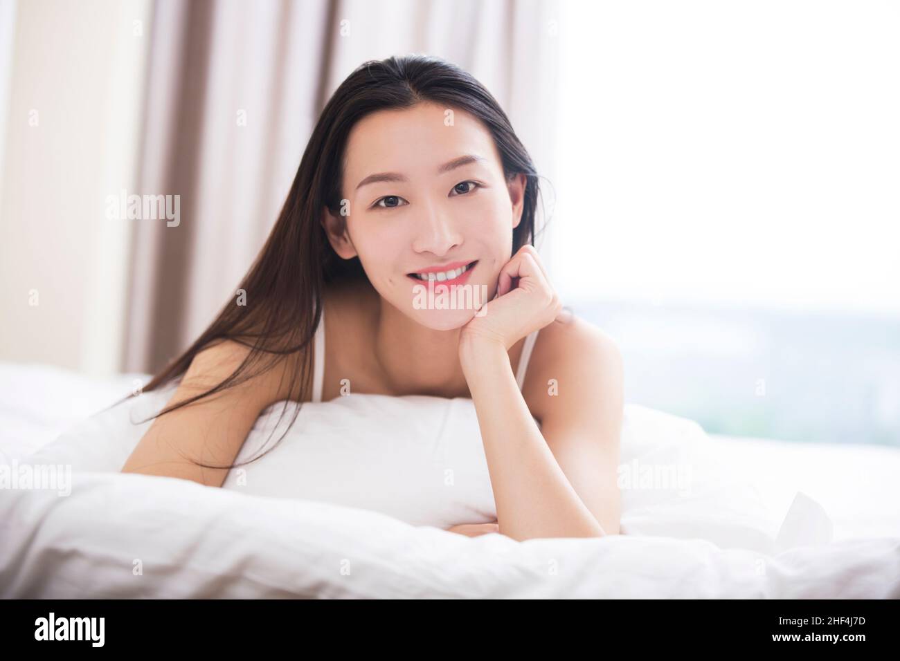 Junge Frau im Bett liegend Stockfoto