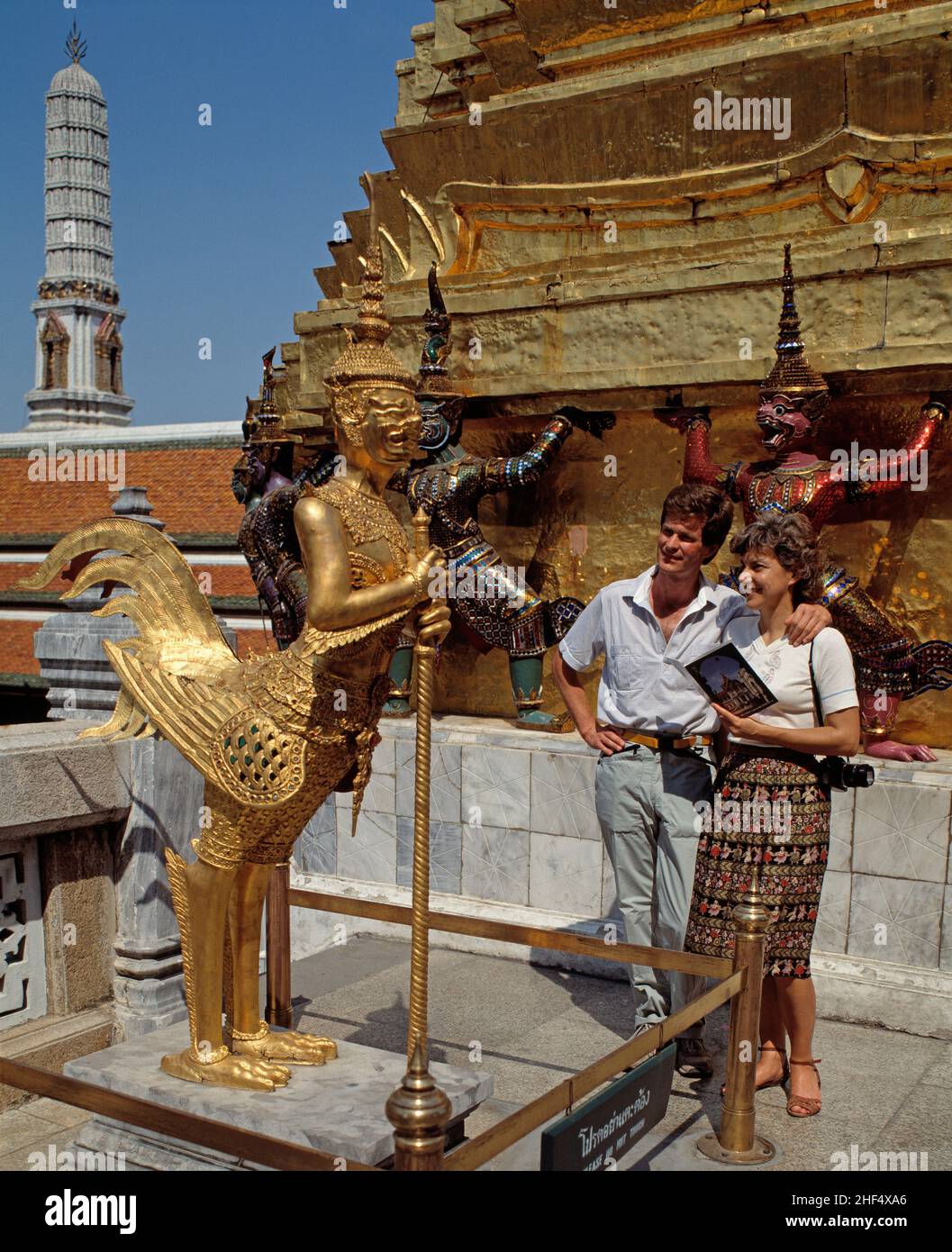 Thailand. Bangkok. Touristenpaar bewundert die goldene Statue im Großen Palast. Stockfoto