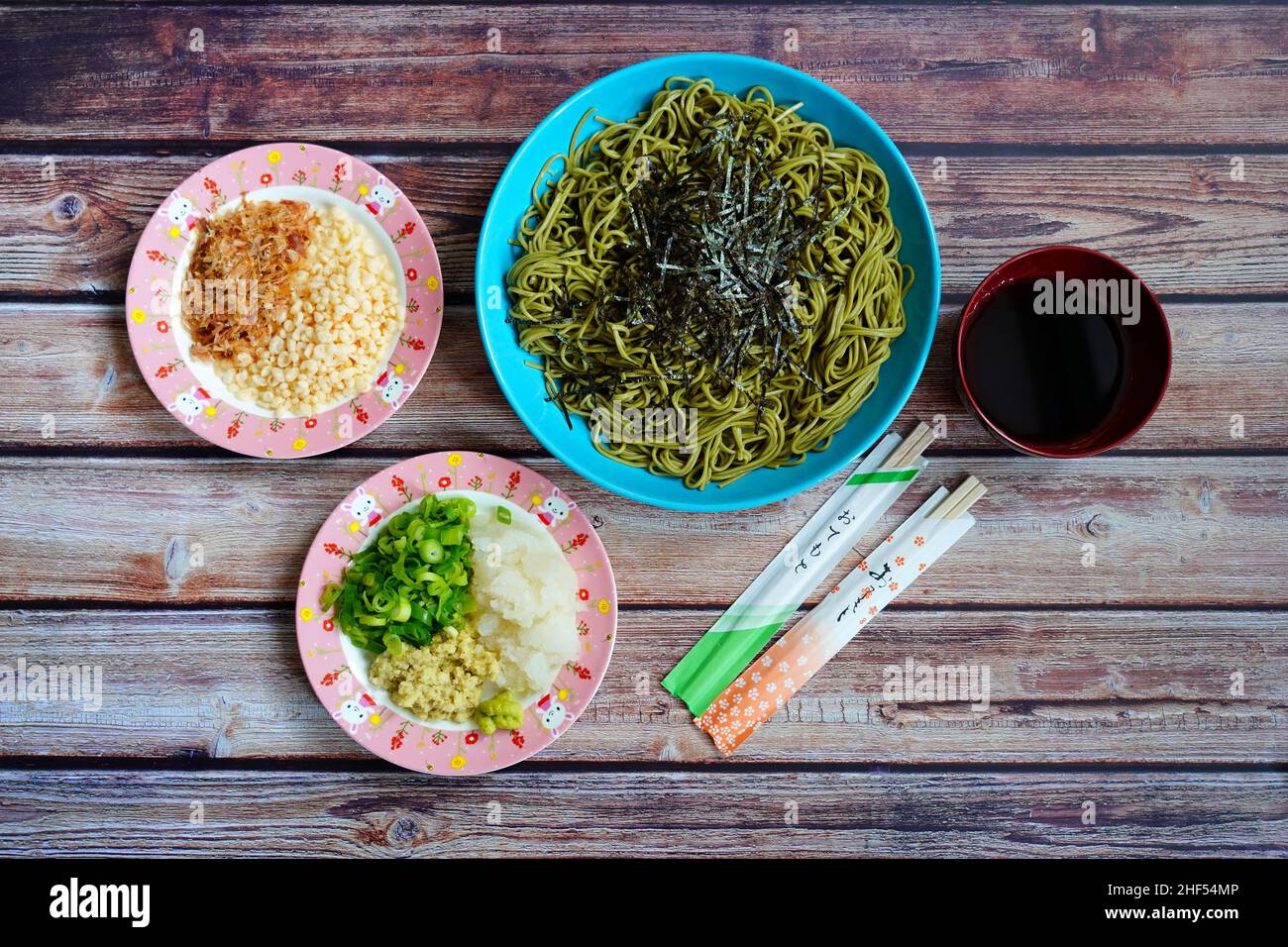 Eine hausgemachte Variante eines japanischen kalten Soba-Gerichts mit Nudeln mit grünem Tee, Nori, Frühlingszwiebeln, Ingwer, Daikon und Sojasauce. Stockfoto