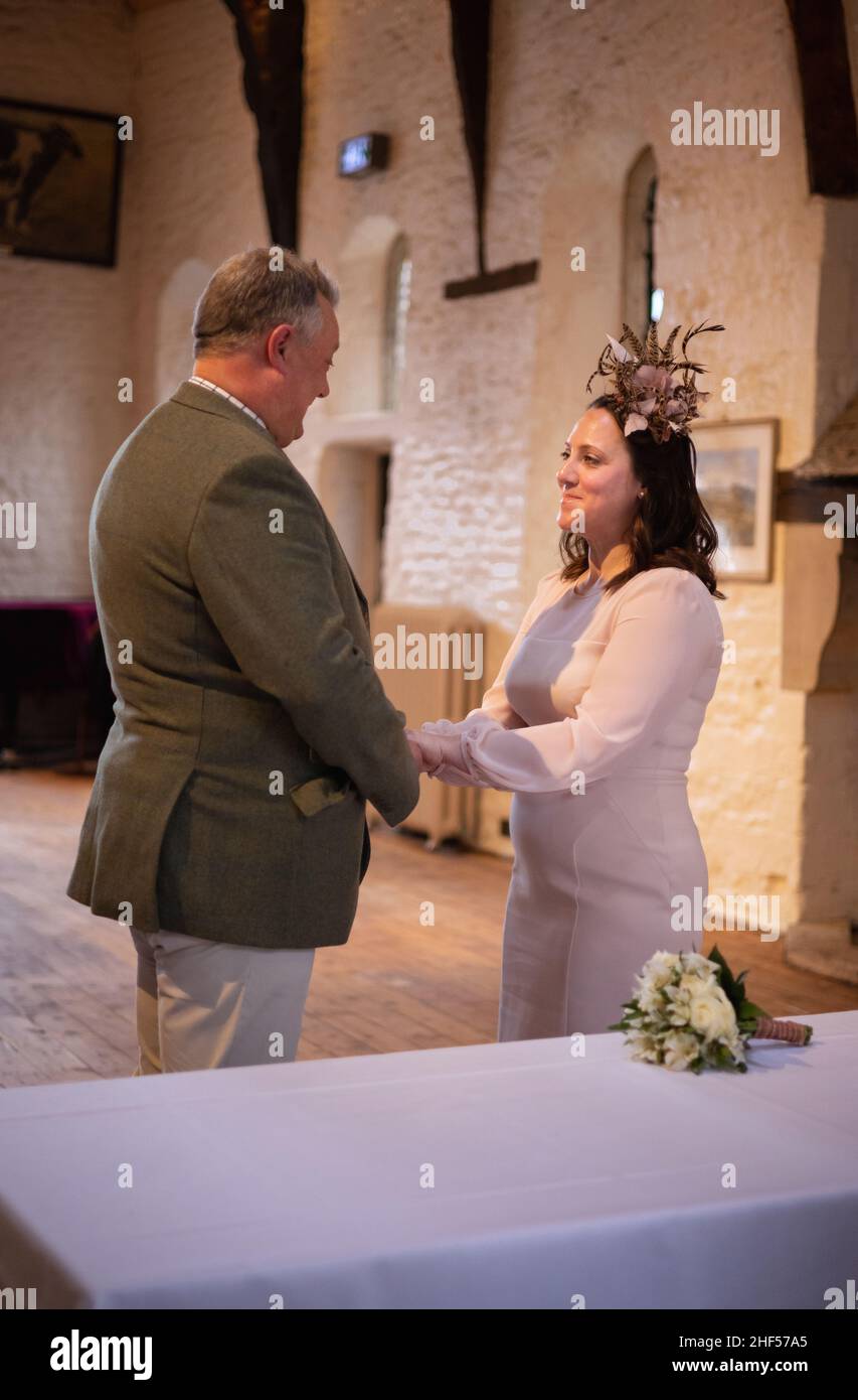 Reifes, glückliches Paar, das in einer kleinen Zeremonie mit covid Distanzierung und Masken heiratet Stockfoto