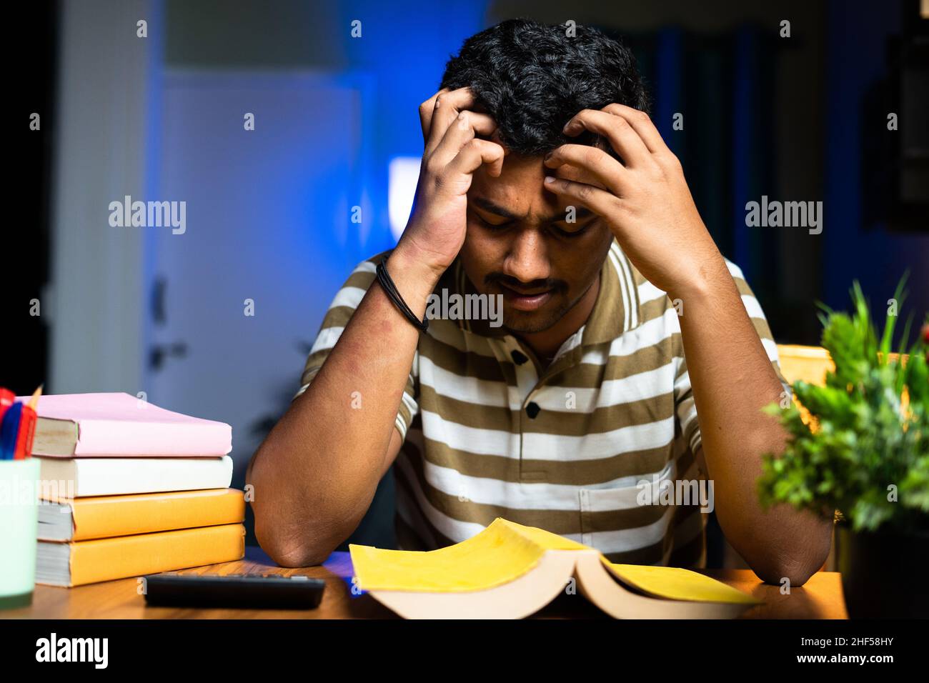 Junge Student Lesung am Mitternacht Prüfungsvorbereitung Lesen nicht verstehen Bücher zu Hause - Konzept des Lesens Problem oder Schwierigkeiten, Schwierigkeiten Stockfoto