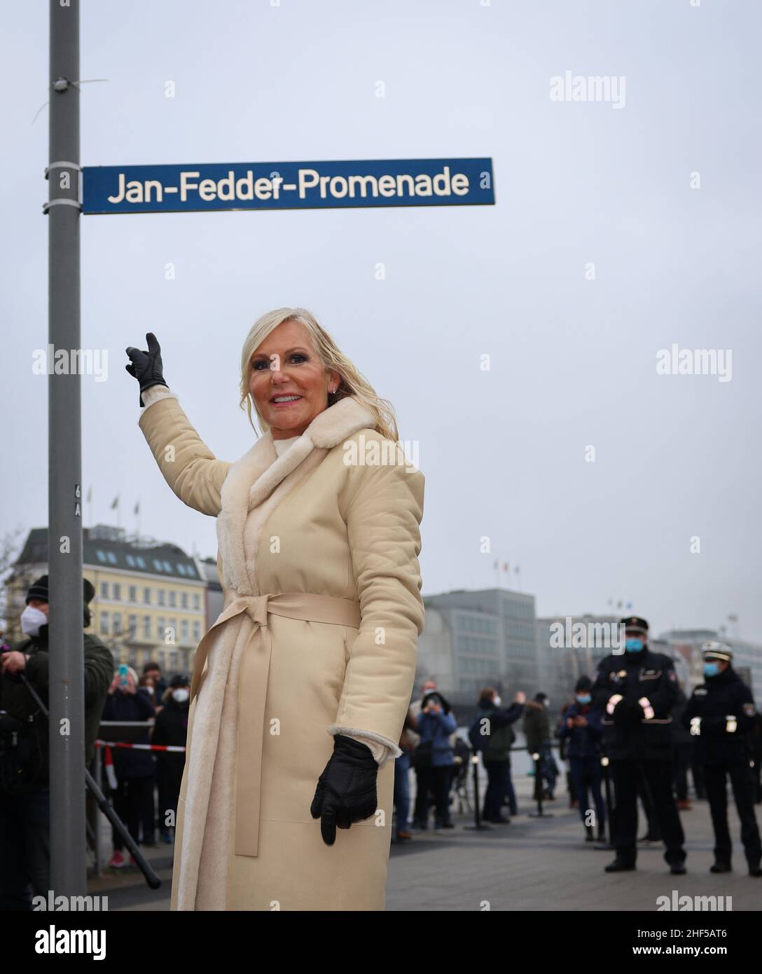 Hamburg, Deutschland. 14th Januar 2022. Marion Fedder, Witwe von Jan Fedder, steht bei einer Fotogelegenheit bei der Einweihung der Jan Fedder Promenade an den Landungsbrücken unter dem neuen Straßenschild. Die Elbpromenade zwischen Landungsbrücken und Baumwall wurde am Freitag nach dem 2019 verstorbenen Hamburger populären Schauspieler benannt. Quelle: Christian Charisius/dpa/Alamy Live News Stockfoto