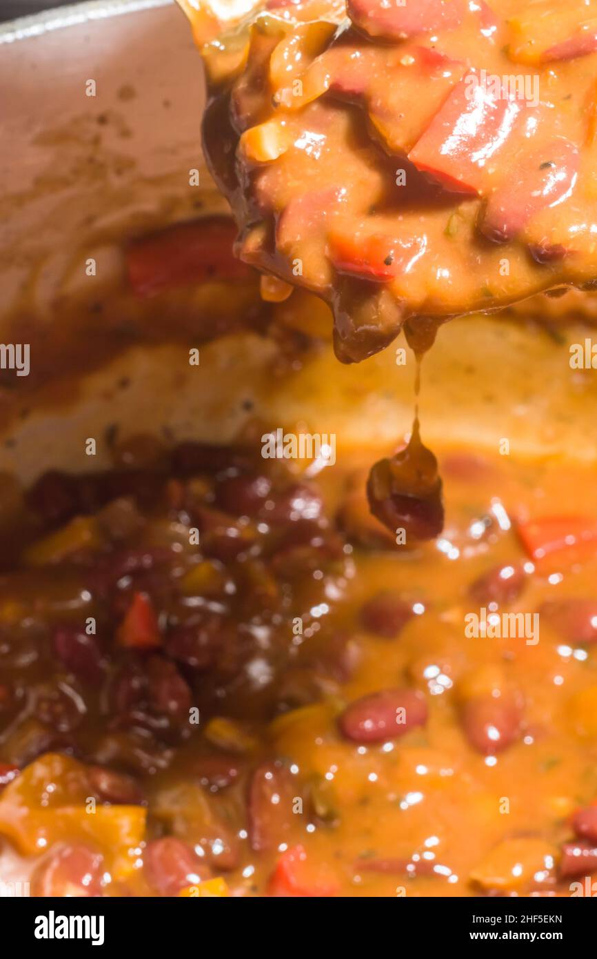 Bohnen mit Gemüse und gelber Sauce in einer Aluminiumpfanne Stockfoto
