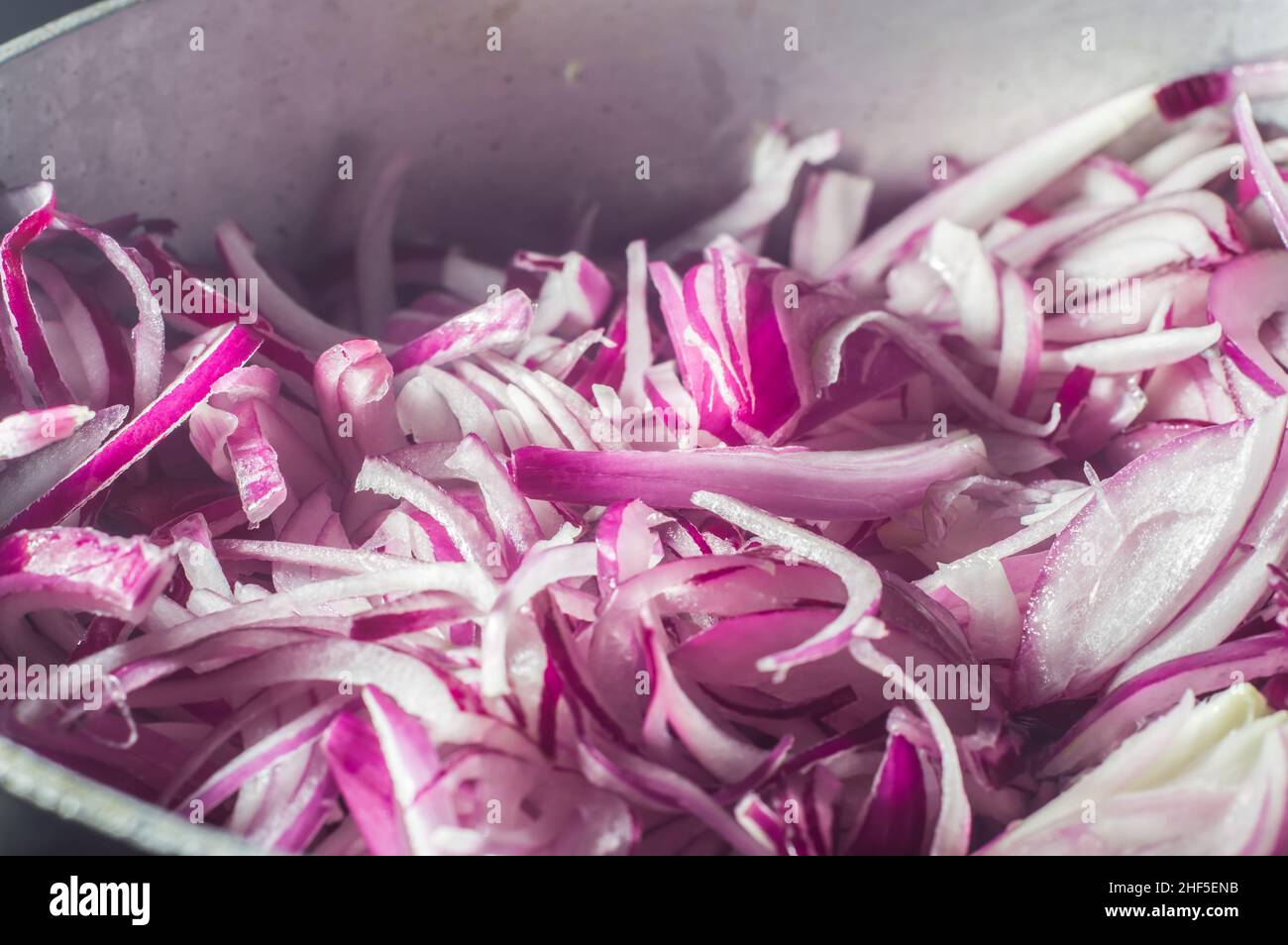 Rote Zwiebel in einer Aluminiumpfanne, Straße im Hintergrund Stockfoto