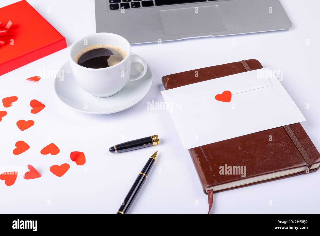 Schwarzer Kaffee mit Liebesbrief, Füllfederhalter und Laptop auf weißem Hintergrund, Kopierplatz Stockfoto