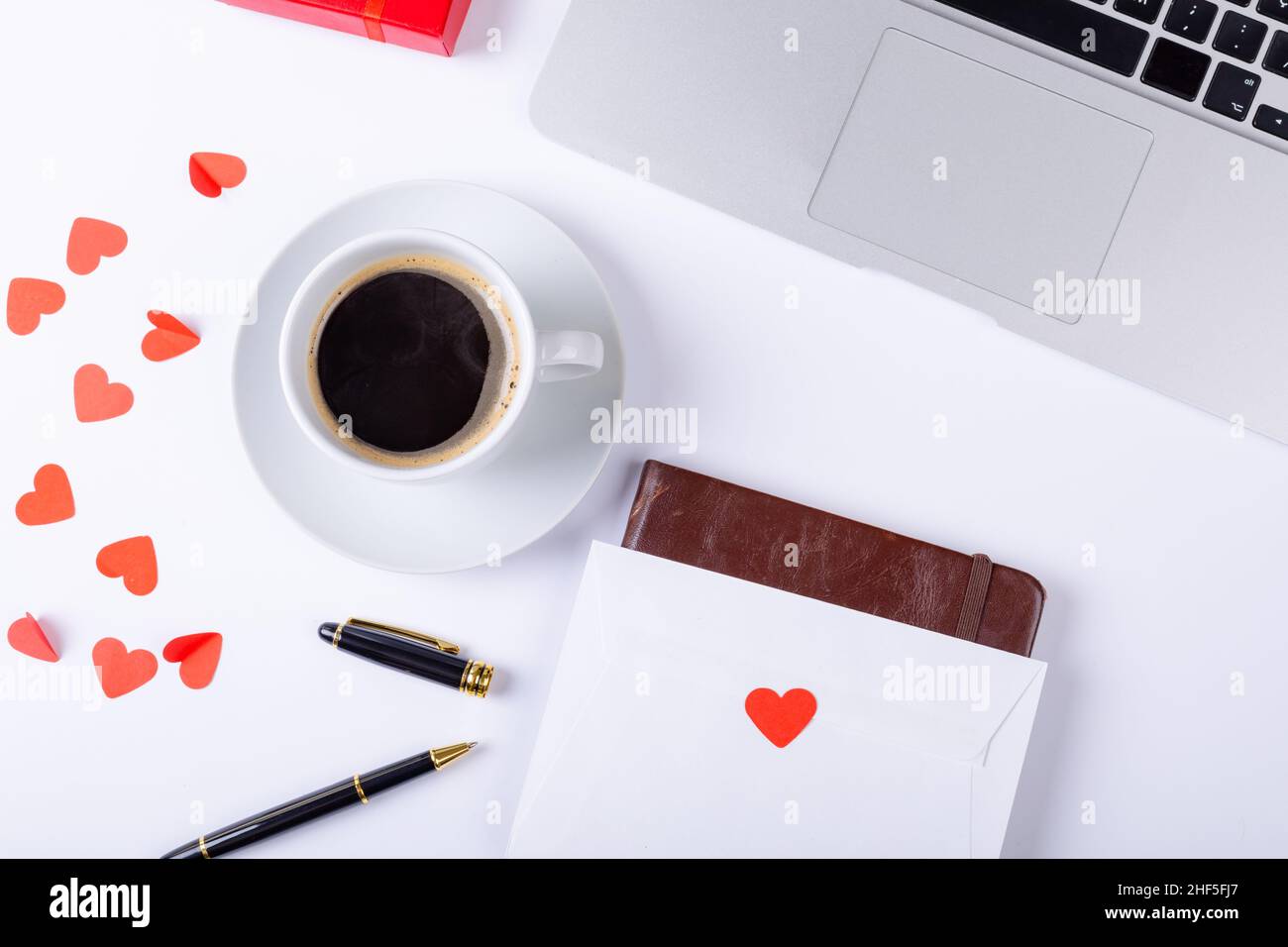 Overhead-Ansicht von schwarzem Kaffee mit Liebesbrief, Füllfederhalter, Laptop auf weißem Hintergrund, Kopierraum Stockfoto