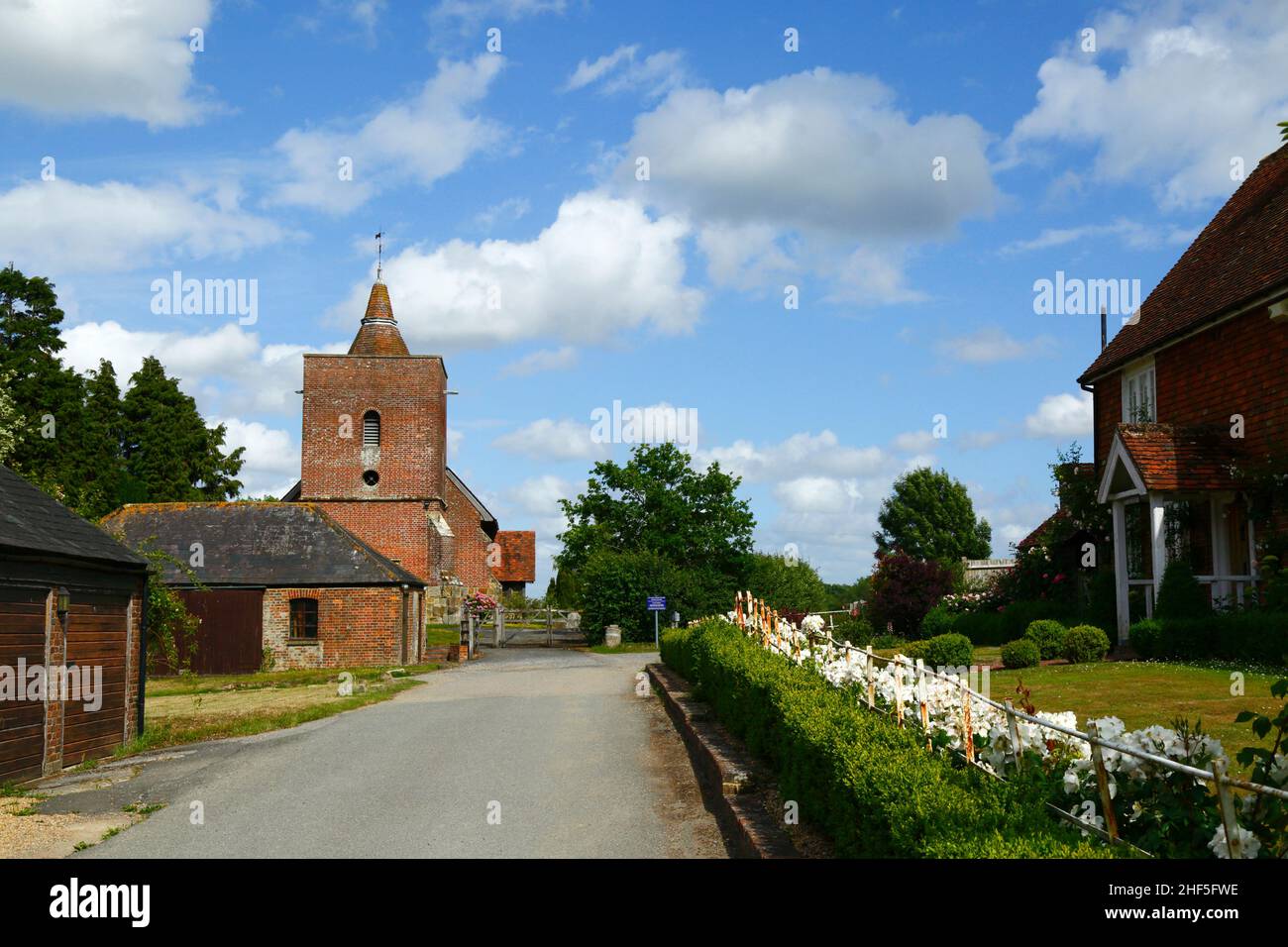 Blick auf die malerische und historische Allerheiligen-Kirche im Dorf Tudeley im Frühsommer, Kent, England Stockfoto