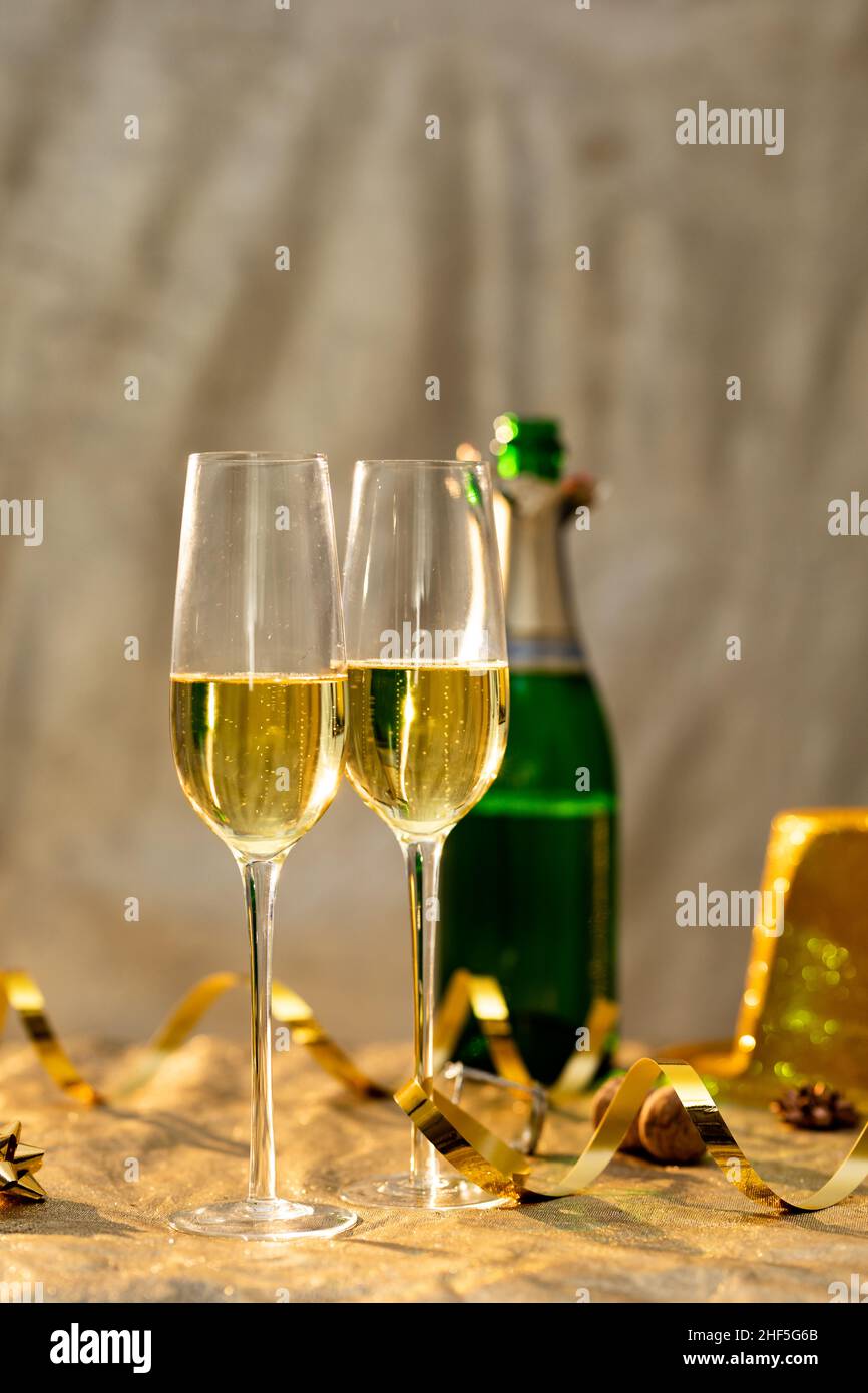 Nahaufnahme von Sektflöten durch goldenes Band vor der Flasche auf dem Tisch Stockfoto