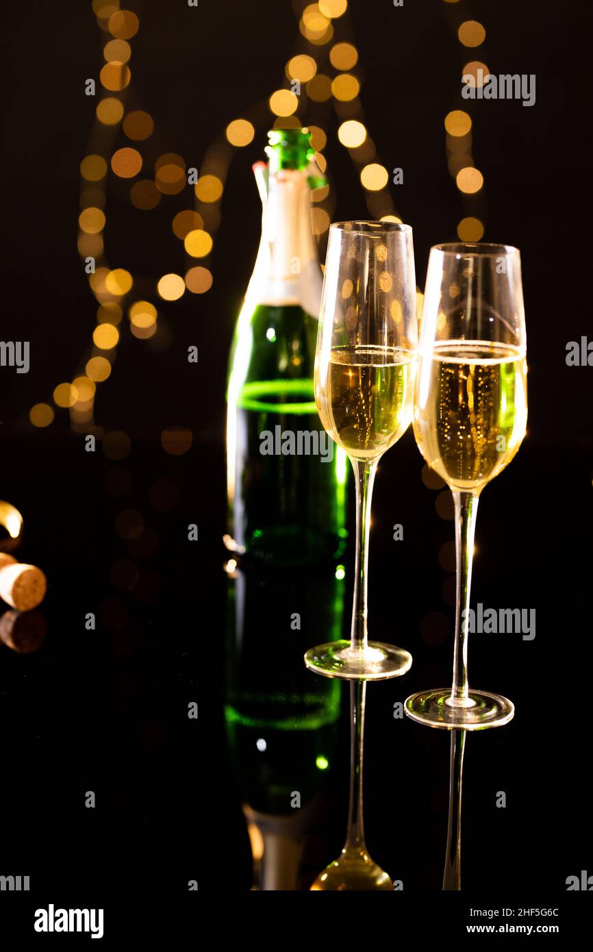 Nahaufnahme des Champagners in Flöten mit einer Flasche, die auf dem Glastisch reflektiert wird Stockfoto