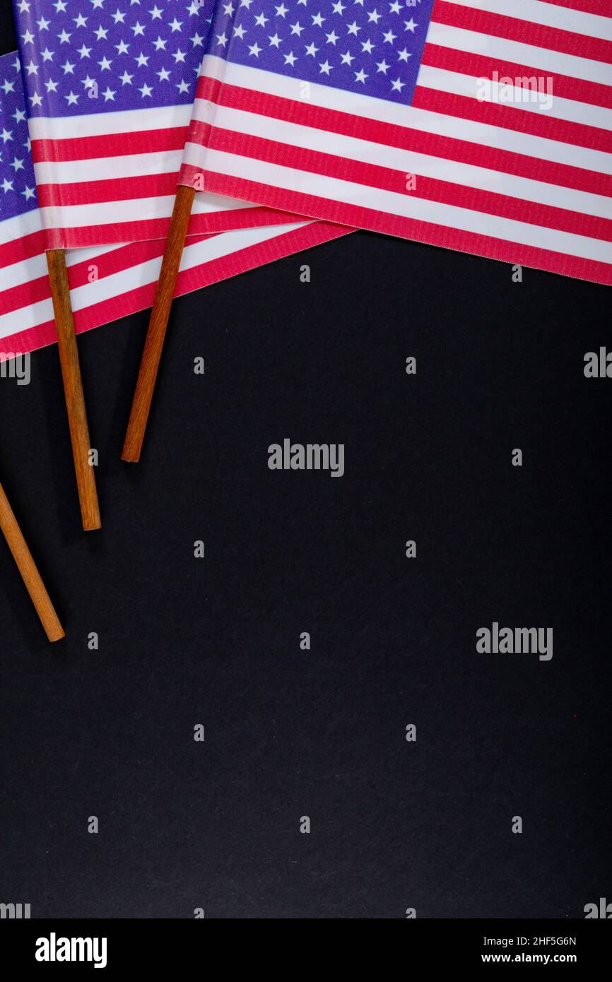 Rot-weiße Streifen zusammen mit Sternen auf usa-Flaggenstäben durch Copy Space auf schwarzem Hintergrund Stockfoto