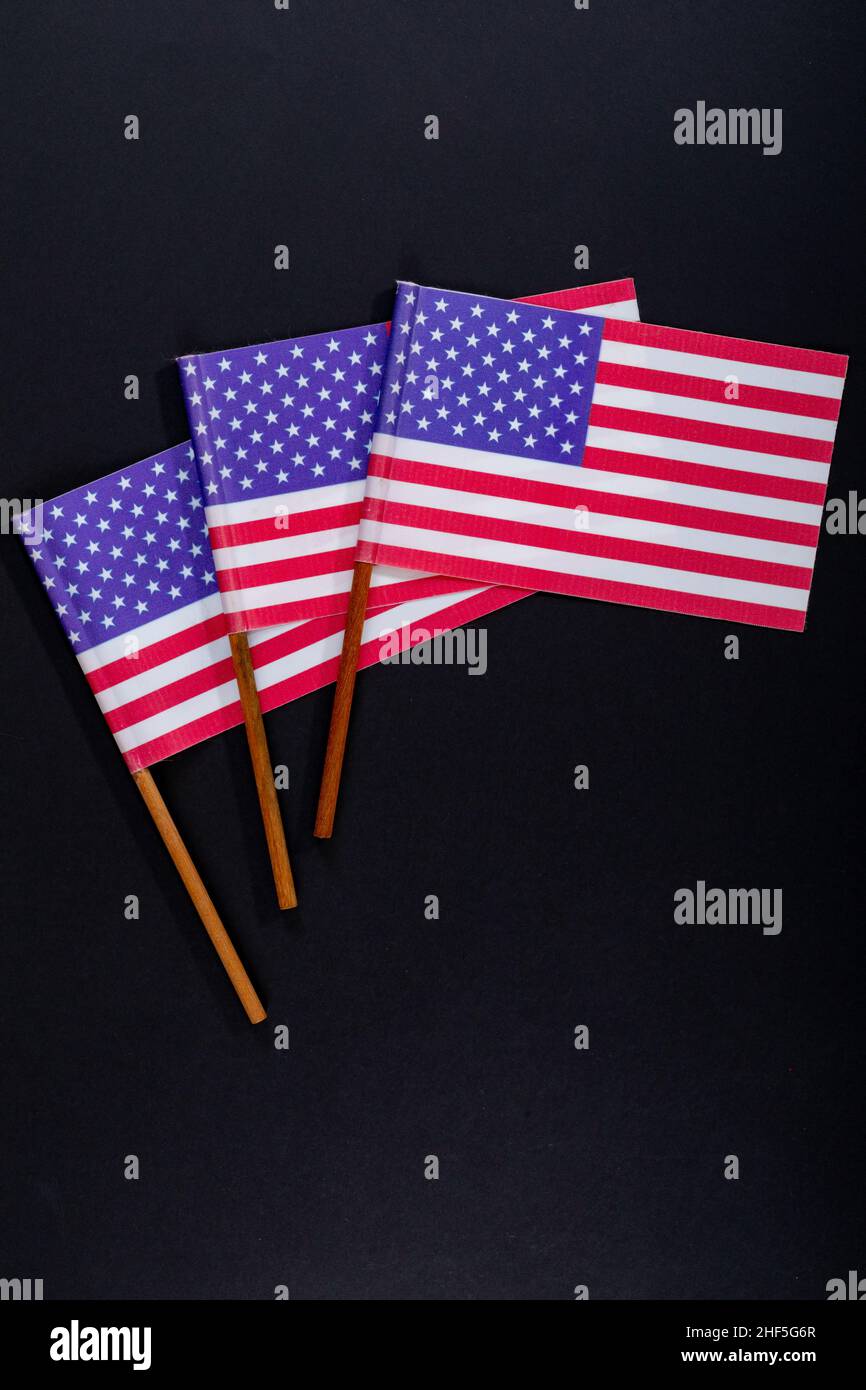 Rote und weiße Streifen zusammen mit Sternen auf amerika-Flaggenstäben auf schwarzem Hintergrund Stockfoto