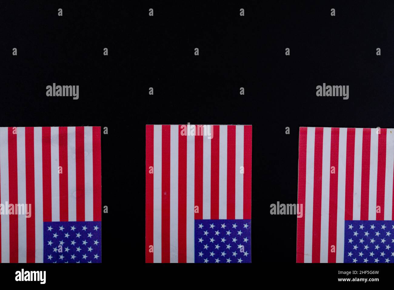 USA-Flaggen mit roten und weißen Streifen zusammen mit Sternen auf schwarzem Hintergrund mit Kopierraum Stockfoto