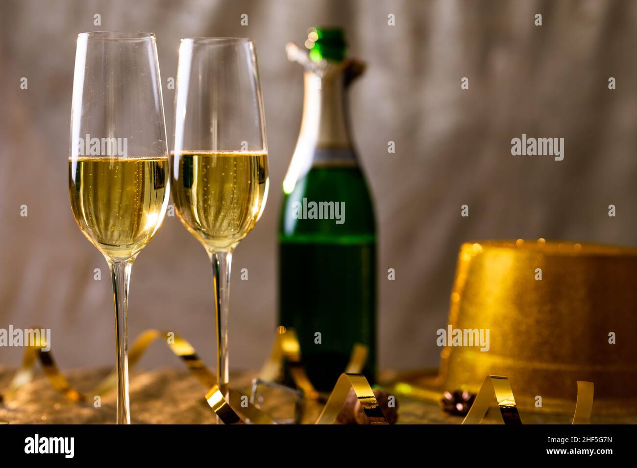 Nahaufnahme von Champagner in Flöten mit goldenem Band per Flasche auf dem Tisch Stockfoto