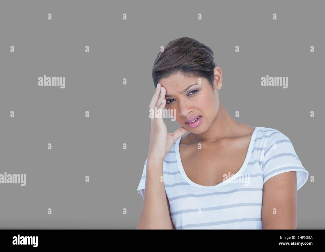 Betonte afroamerikanische junge Frau gegen den Kopierraum auf grauem Hintergrund Stockfoto