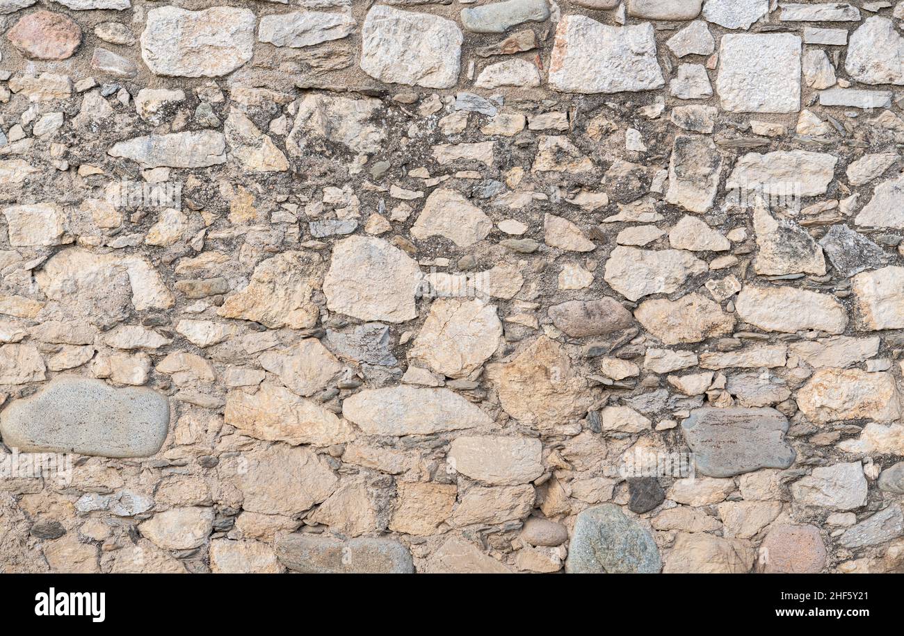 Alte Steinwandstruktur mit verschiedenen Steingrößen. Hintergrund Stockfoto