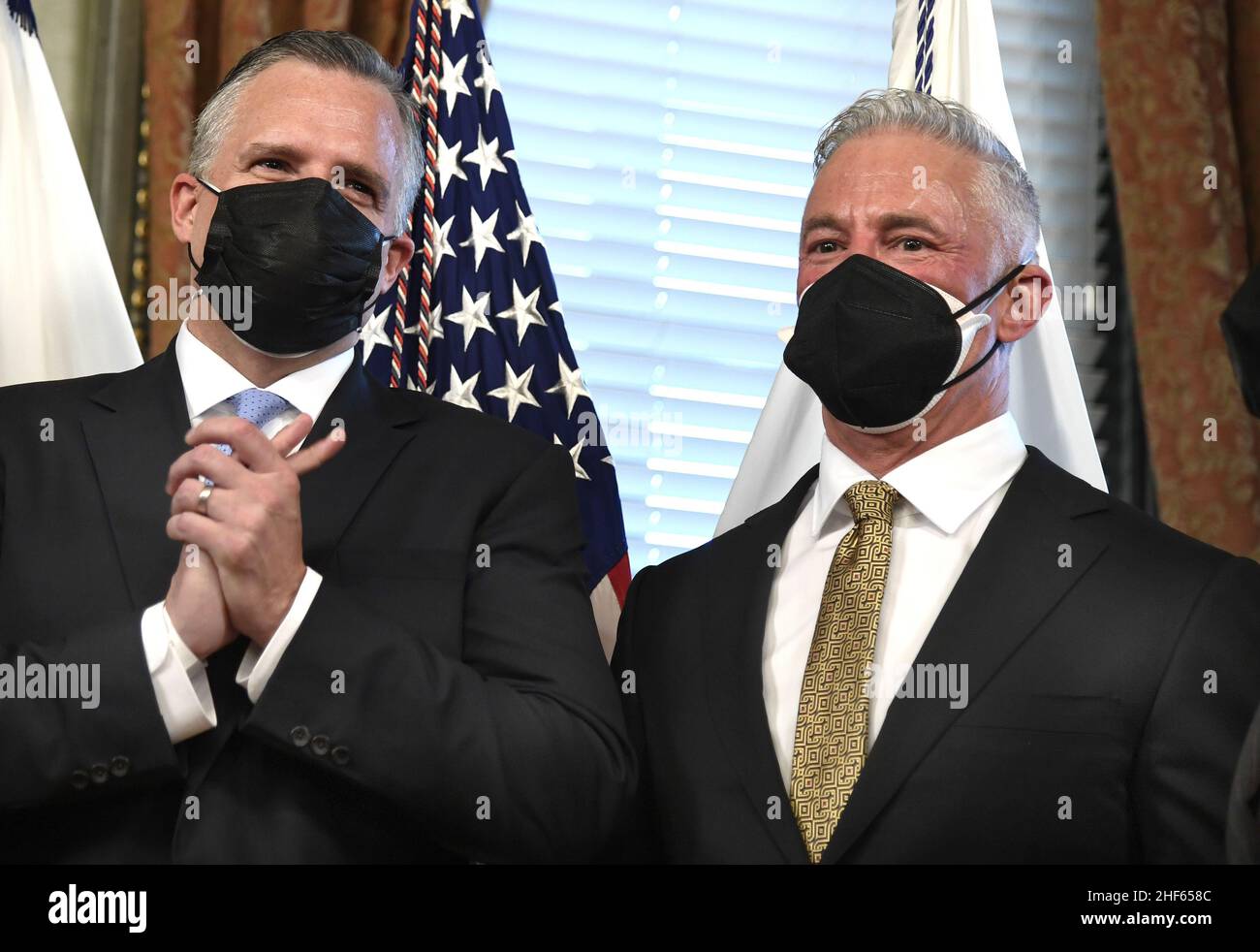 Washington, Usa. 14th Januar 2022. Der Protokollchef des Außenministeriums, Rufus Gifford (L), hält sich die Hände fest, nachdem er von Vizepräsident Kamala Harris vereidigt wurde, als sein Ehemann, Stephen DeVincent (R), am Freitag, den 14. Januar 2022 in Washington, DC. Gifford, ehemals US-Botschafter in Dänemark, wird eine führende Rolle im diplomatischen Engagement der Regierung von Präsident Biden übernehmen. Foto von Mike Theiler/UPI Credit: UPI/Alamy Live News Stockfoto