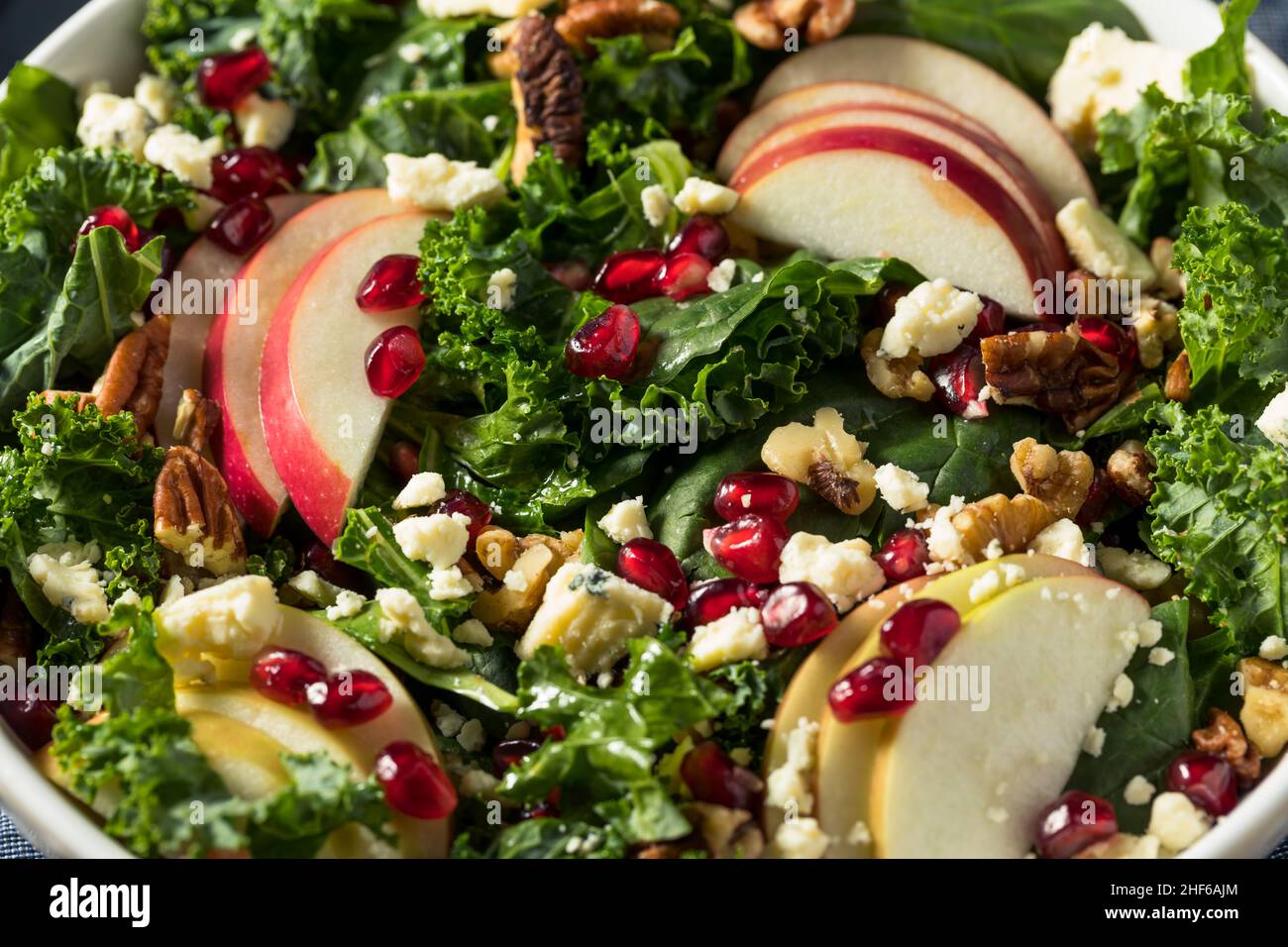 Hausgemachter Apfelsalat aus Herbstgranatapfel mit Grünkälge Stockfoto