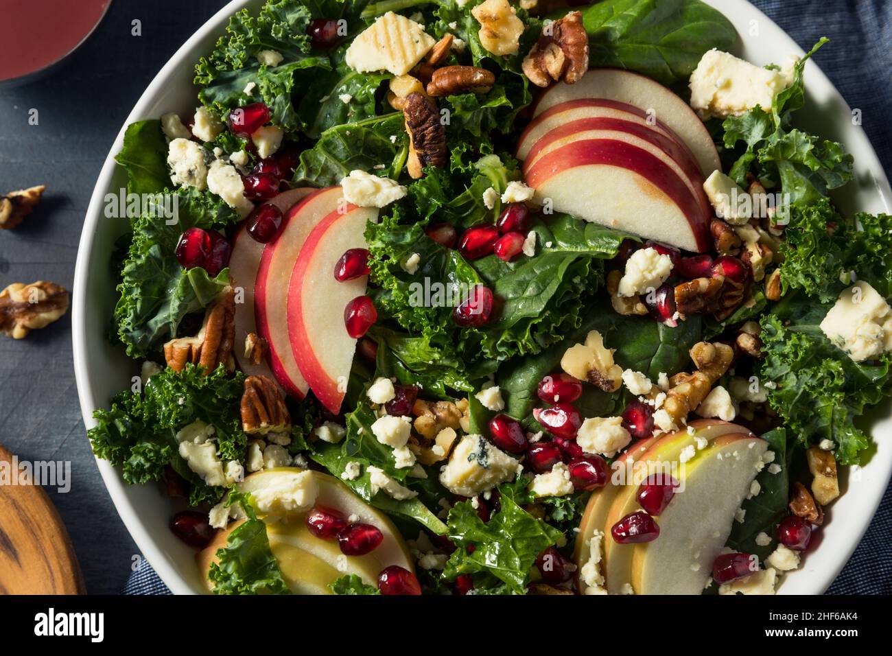 Hausgemachter Apfelsalat aus Herbstgranatapfel mit Grünkälge Stockfoto