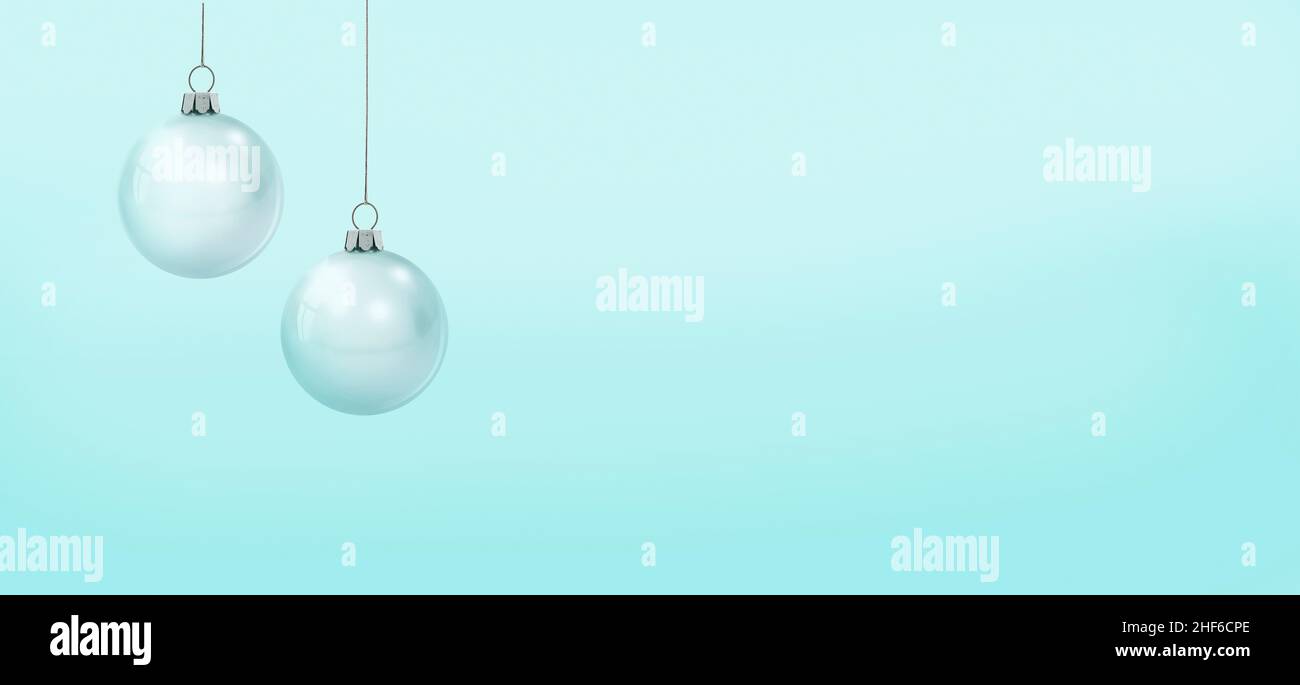 Weiße Weihnachtskugeln vor einem pastellfarbenen blauen Hintergrund Stockfoto