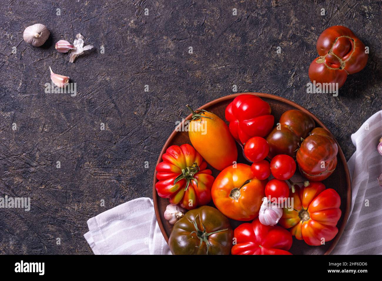 Die Ernte von verschiedenen Tomaten. Bunte Bio-Tomaten auf einem großen Teller. Tomaten verschiedene Sorten. Draufsicht Stockfoto