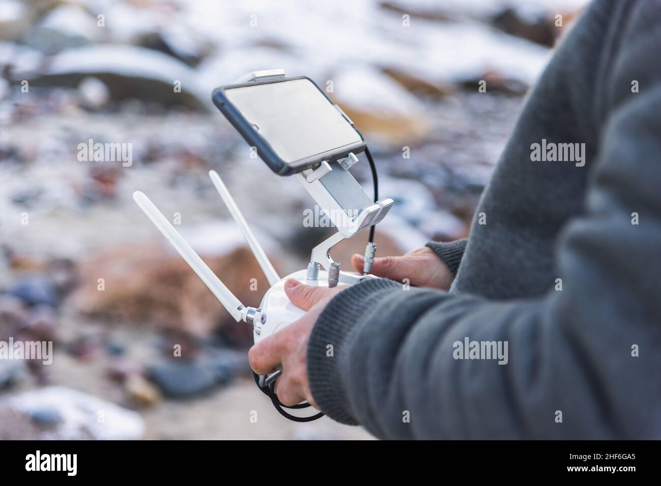 Männliche Hände halten das Fernbedienfeld der Drohne für Luftaufnahmen mit witzloser moderner Technologie Stockfoto