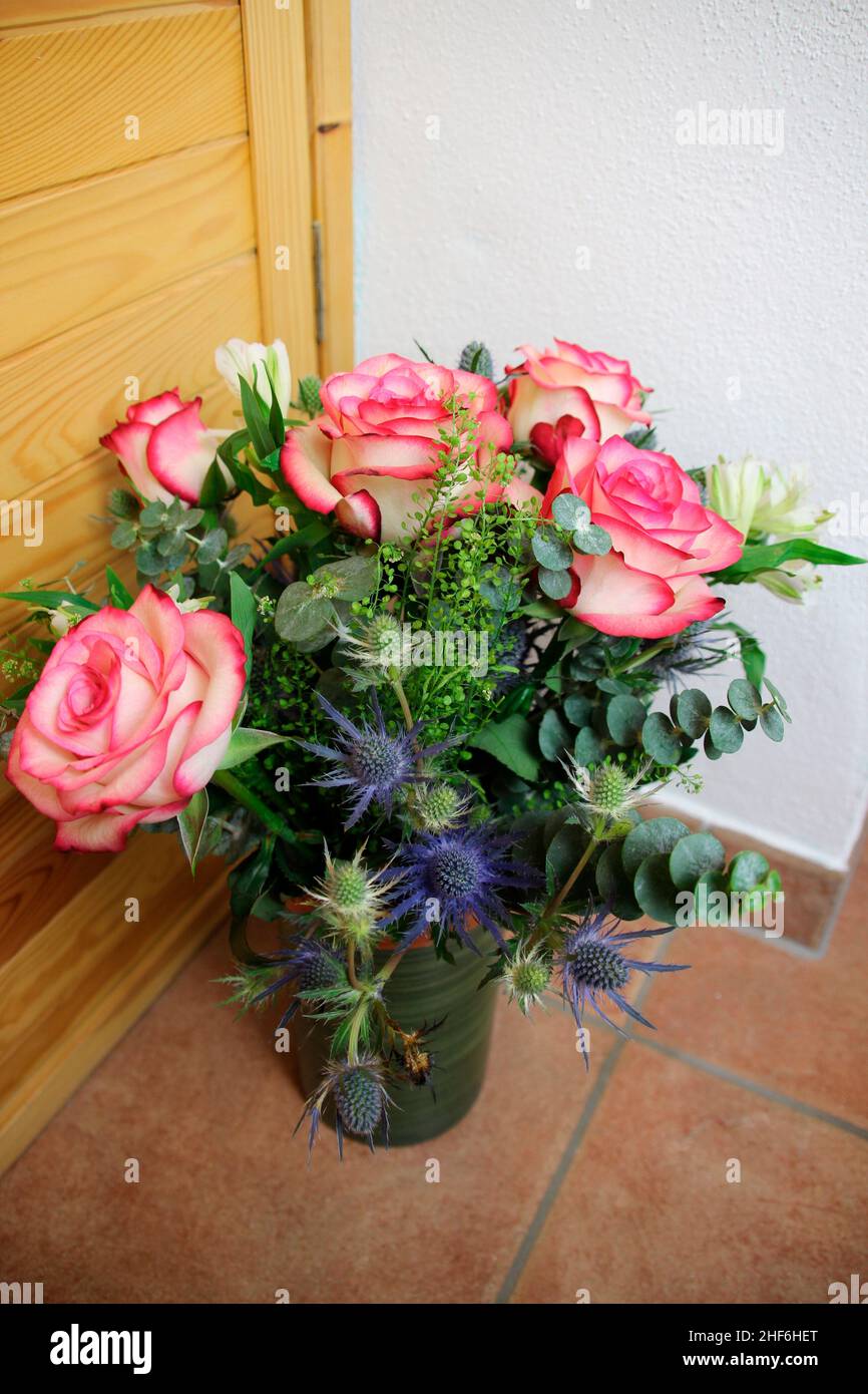 Bouquet mit rosa Rosen, Nahaufnahme, Vase, Fliesenboden blaue Disteln Stockfoto