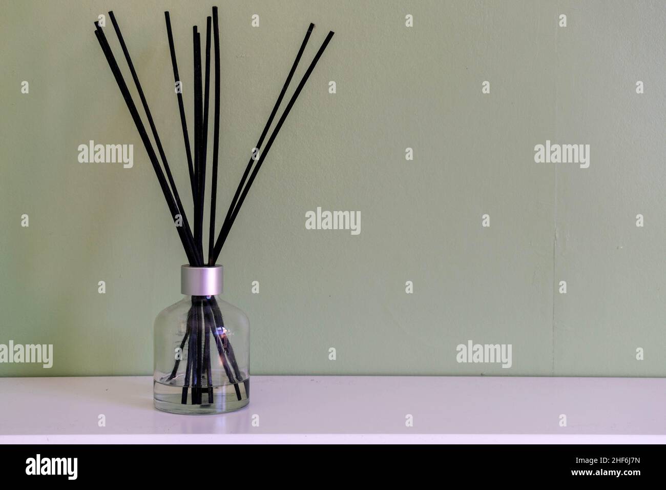 Ein Reed Diffusor in einem Glas mit schwarzen Sticks, Home Lifestyle Dekor Hintergrundkonzepte mit Platz für Text kopieren. Dekorative Aromatherapie gemütlich Stockfoto