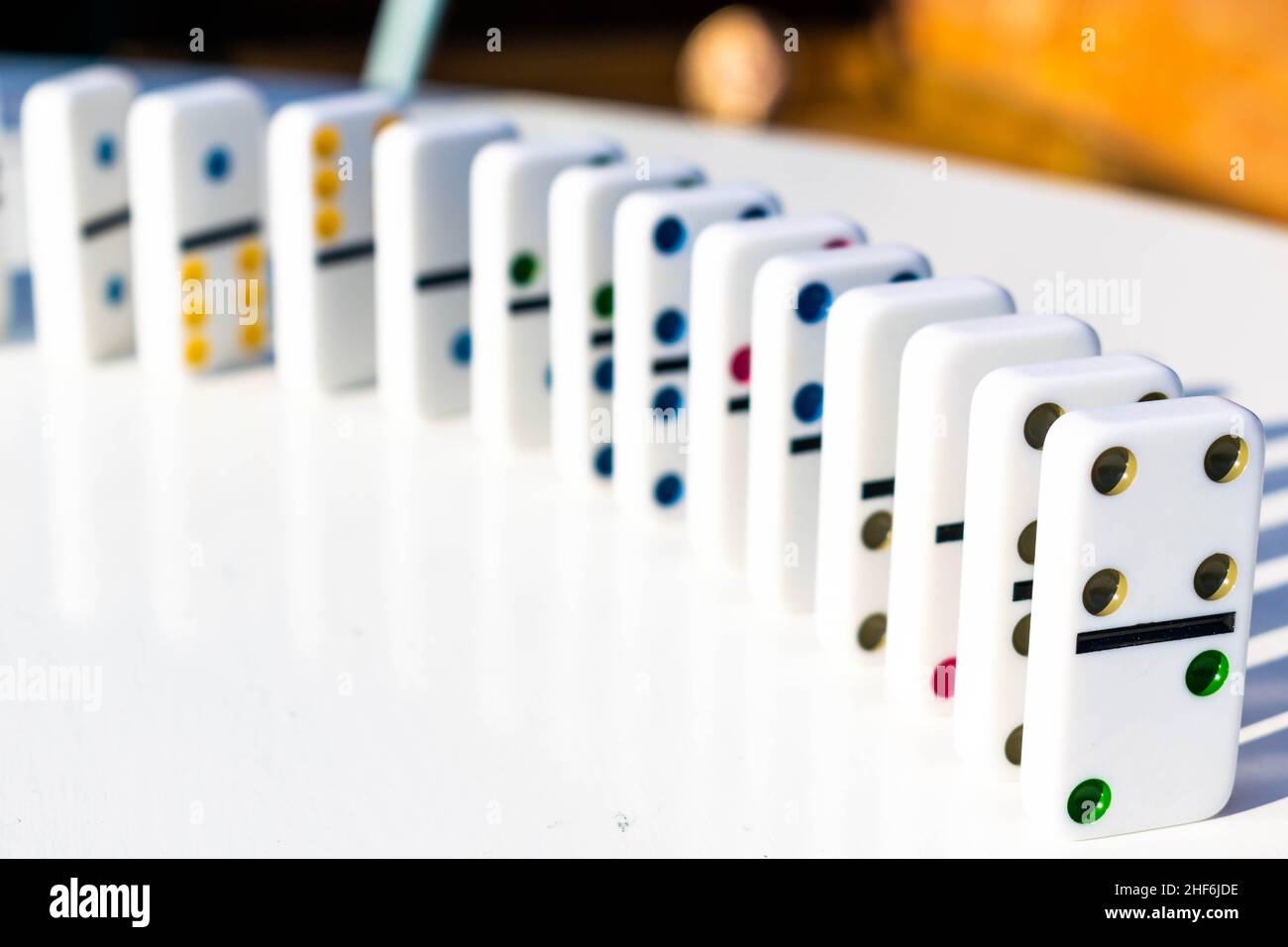Weiße Domino-Fliesen stehen ordentlich auf einem weißen Tisch, bereit, geschoben oder umgestürzt zu werden. Konzept für Familienspaß und Dominospiele, Organisation, OTC Stockfoto