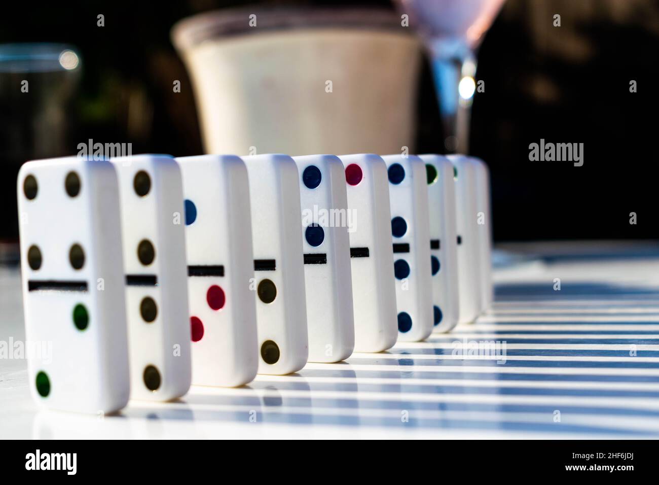 Weiße Domino-Fliesen stehen ordentlich auf einem weißen Tisch, bereit, geschoben oder umgestürzt zu werden. Konzept für Familienspaß und Dominospiele, Organisation, OTC Stockfoto