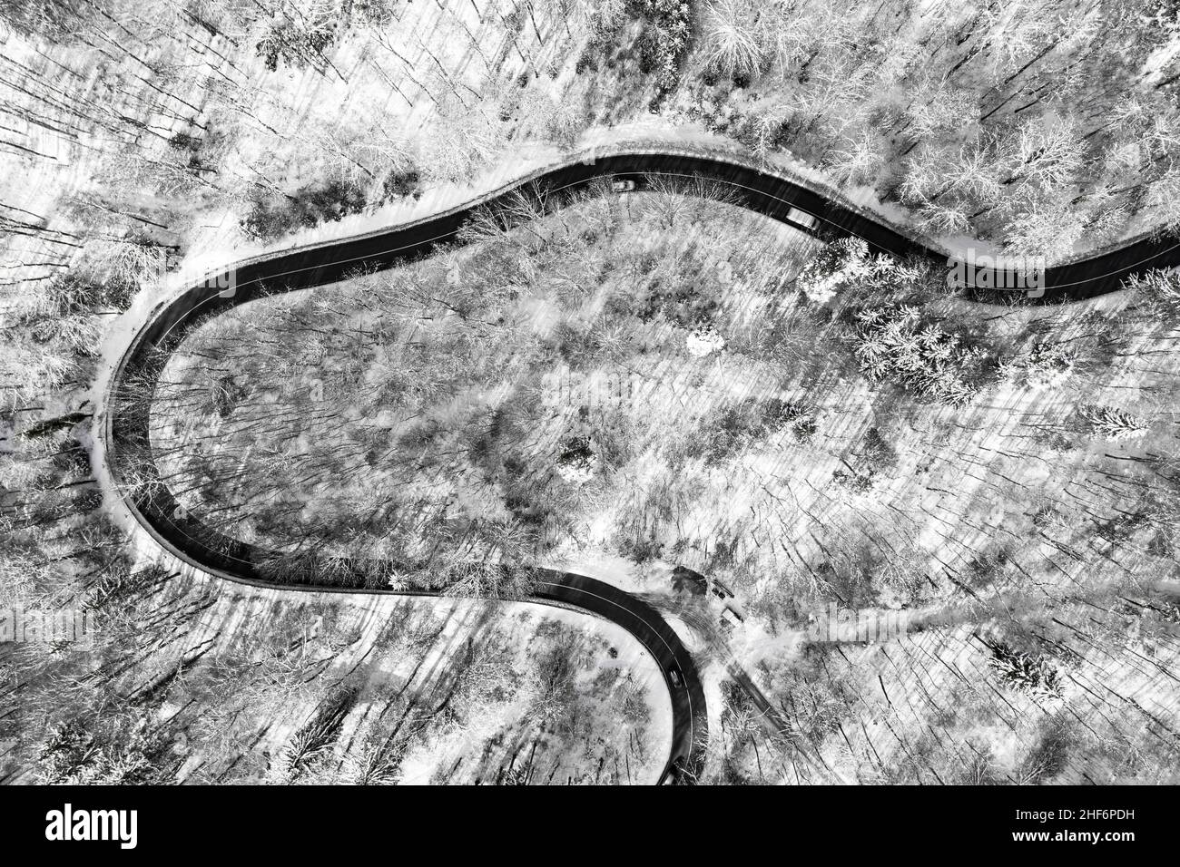 Luftaufnahme auf einer kurvigen Straße als Topdown-Aufnahme im Winter mit der Straße umgeben von dem weißen sauberen Schnee Stockfoto