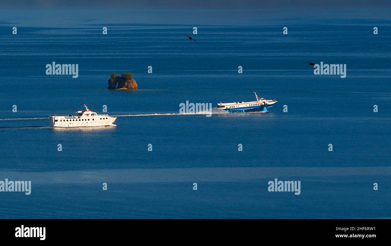 Griechenland, Griechische Inseln, Ionische Inseln, Korfu, Korfu-Stadt, Alte Festung, Blick von dort über das Meer und die vorgelagerte Felseninsel, davor zwei Boote: Links eine normale kleine Fähre, rechts ein schnelles Tragflächenboot Stockfoto