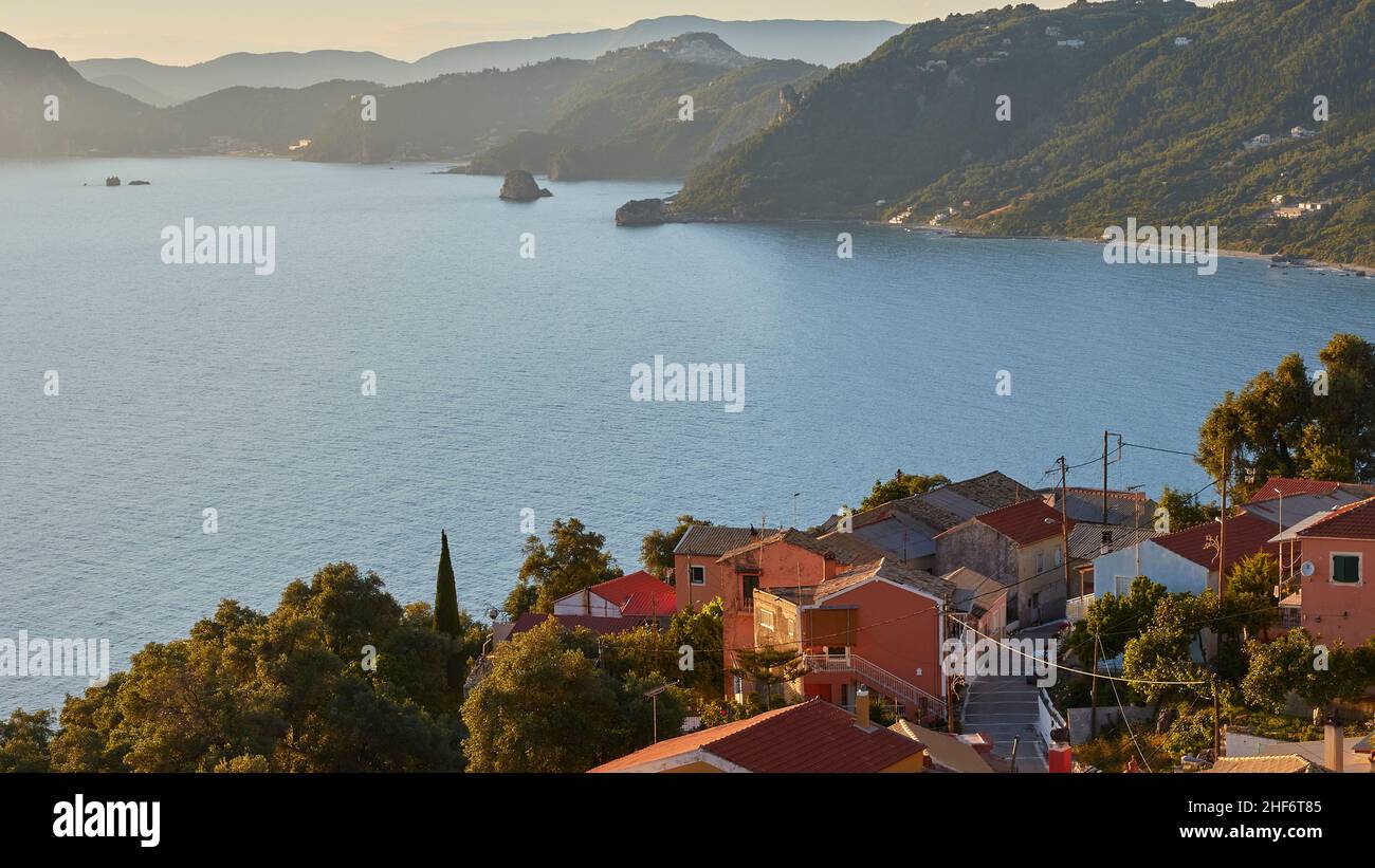 Griechenland, griechische Inseln, Ionische Inseln, Korfu, Westküste, Pentati, spätnachmittags Licht, Blick auf einen Teil von Pentati und hinunter zur Küste von Agios Gordios, grüne Berge im Hintergrund Stockfoto