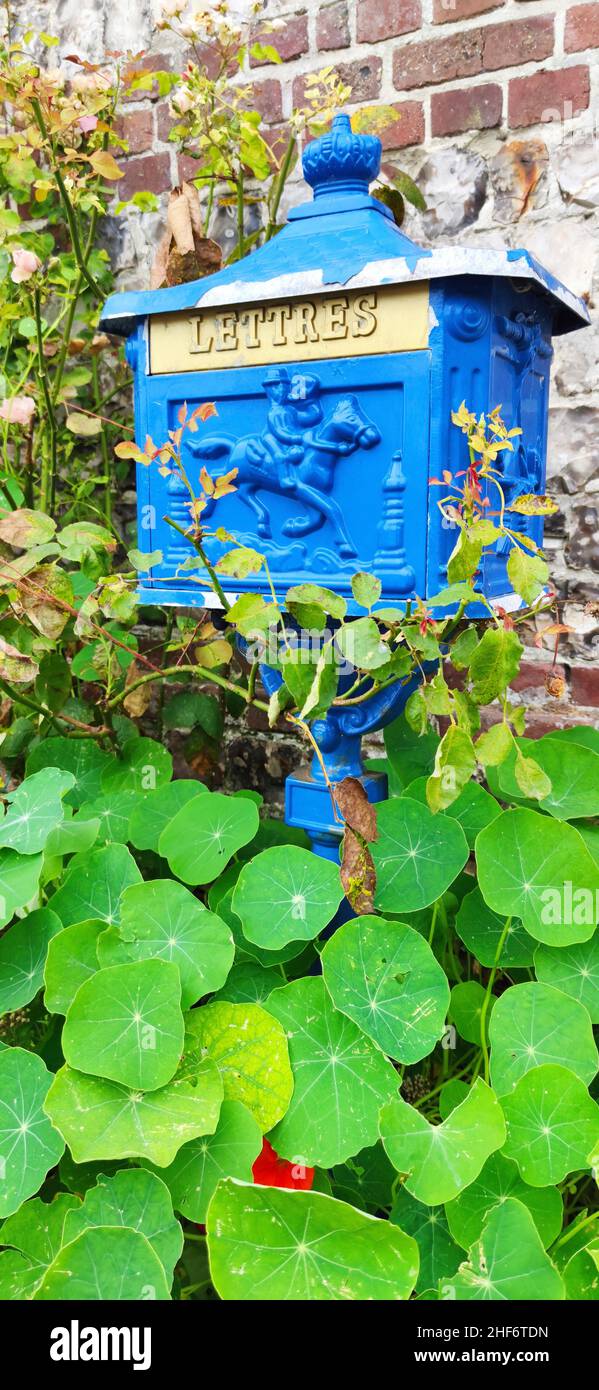 Blauer Briefkasten vor Backsteinmauer Frankreich, Normandie, Stockfoto