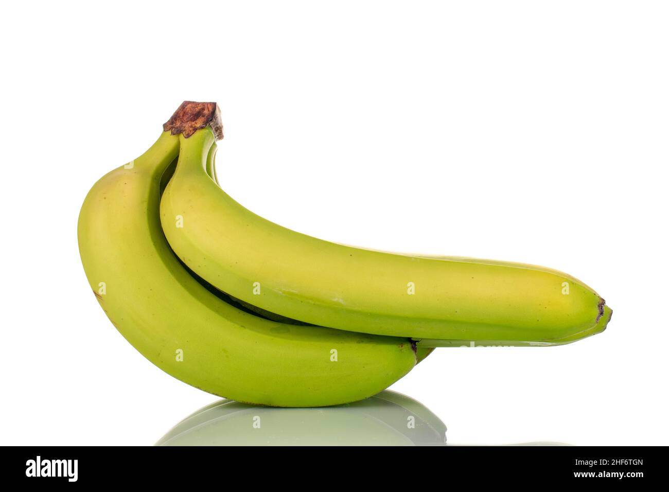 Drei organische grüne Bananen, Makro, isoliert auf weiß. Stockfoto