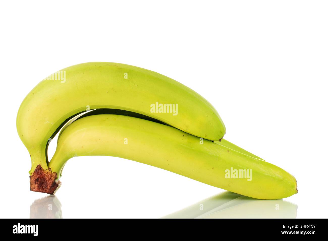 Drei organische grüne Bananen, Makro, isoliert auf weiß. Stockfoto