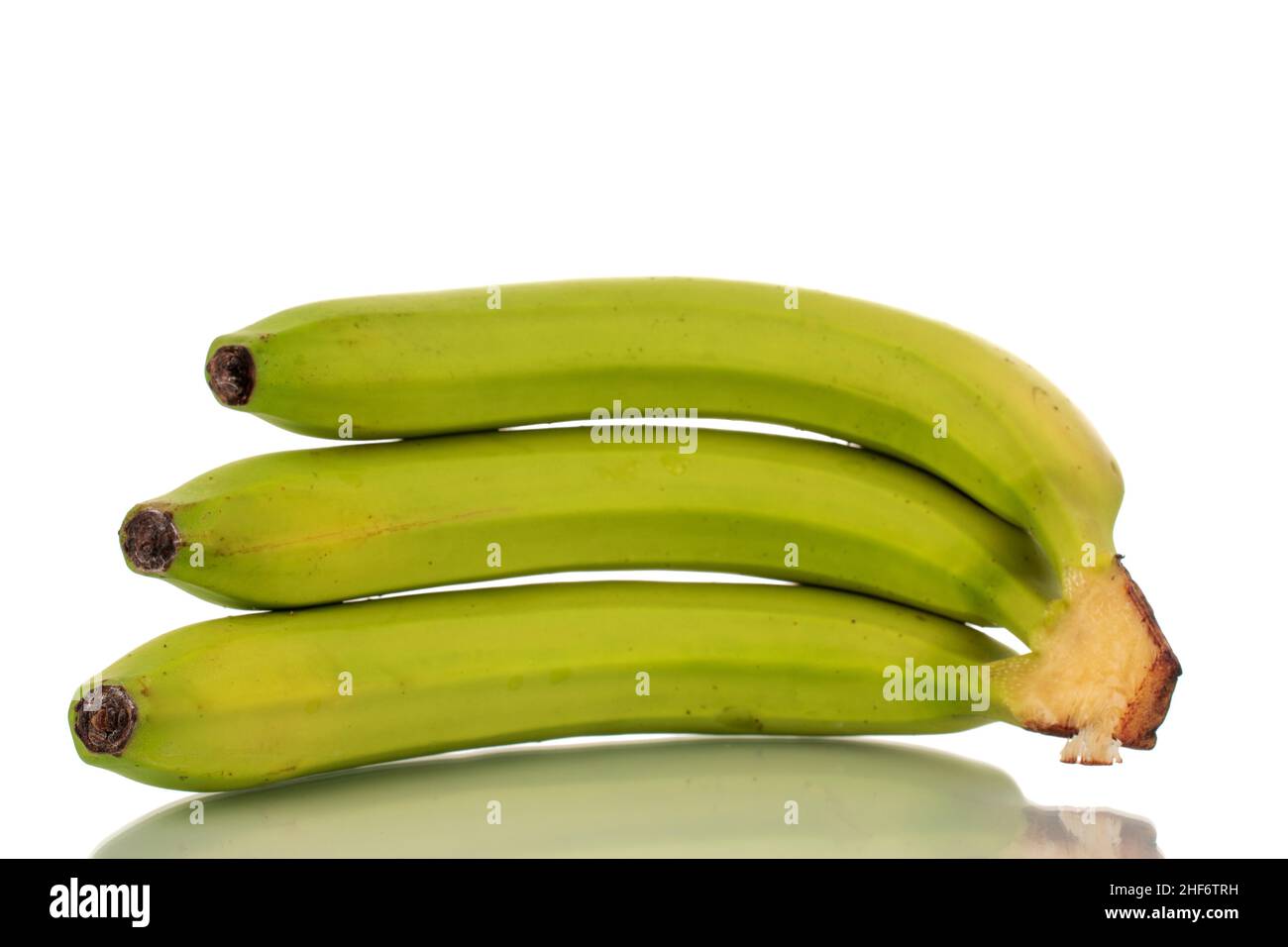 Drei organische grüne Bananen, Makro, isoliert auf weiß. Stockfoto
