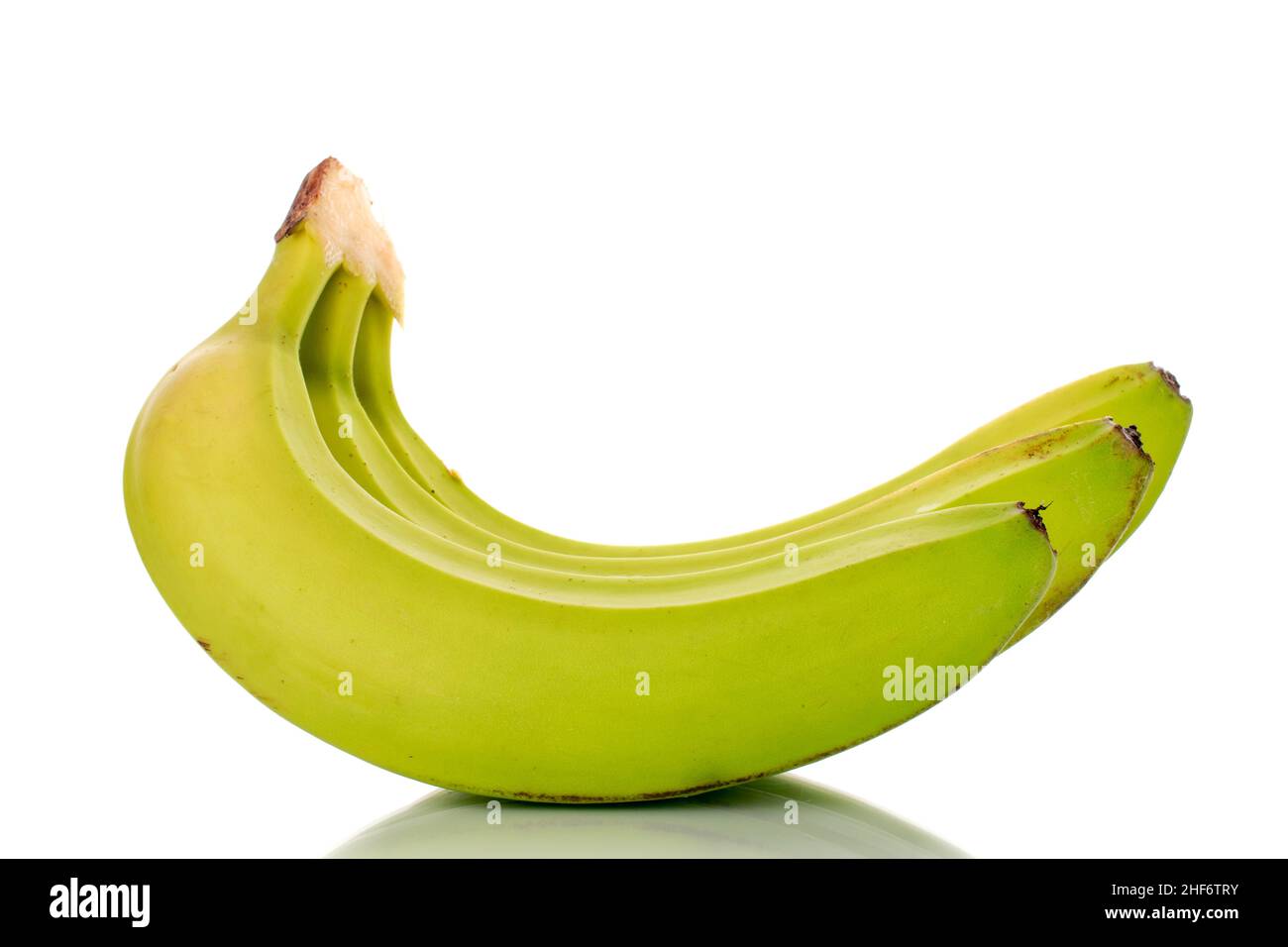 Drei organische grüne Bananen, Makro, isoliert auf weiß. Stockfoto